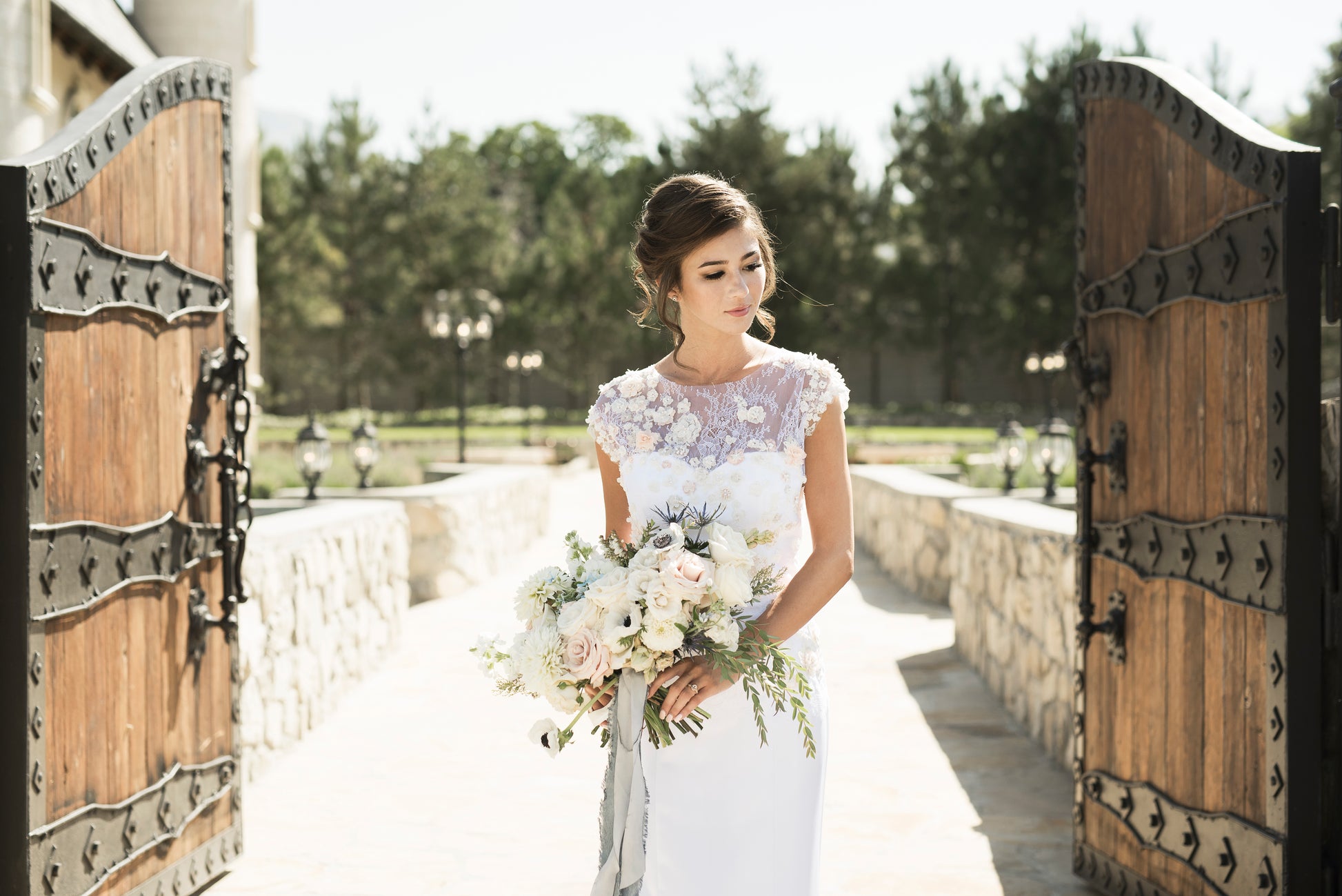 A front view of the naomi gown from the thighs up; the Bold mermaid silhouette in satin with floral lace detailing is here in blush / white.