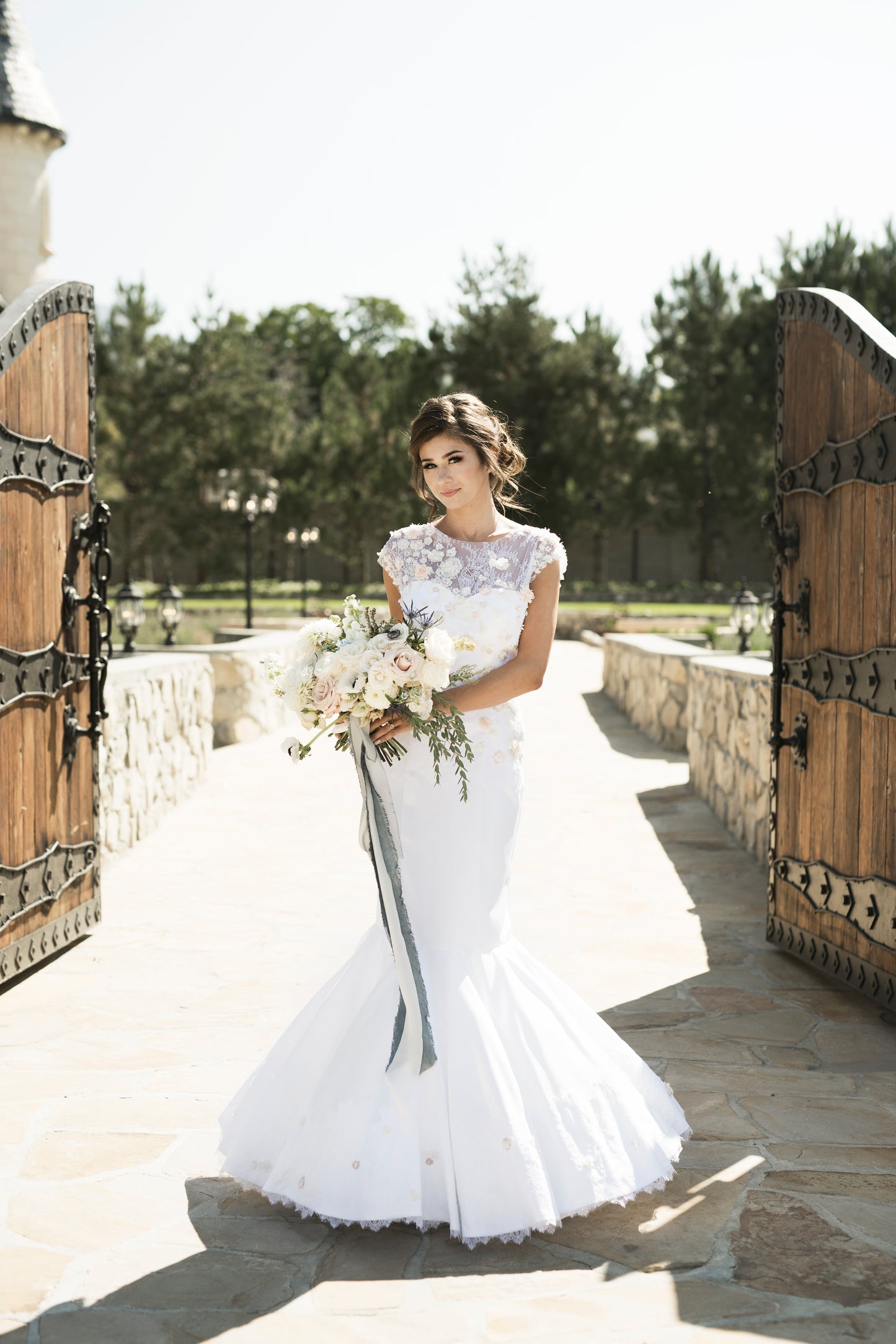 A full front view of the naomi mermaid stretch satin wedding gown, the satin sweetheart neckline has the 3d lace overlay that rises up into a cap sleeve and boat neck overlay.