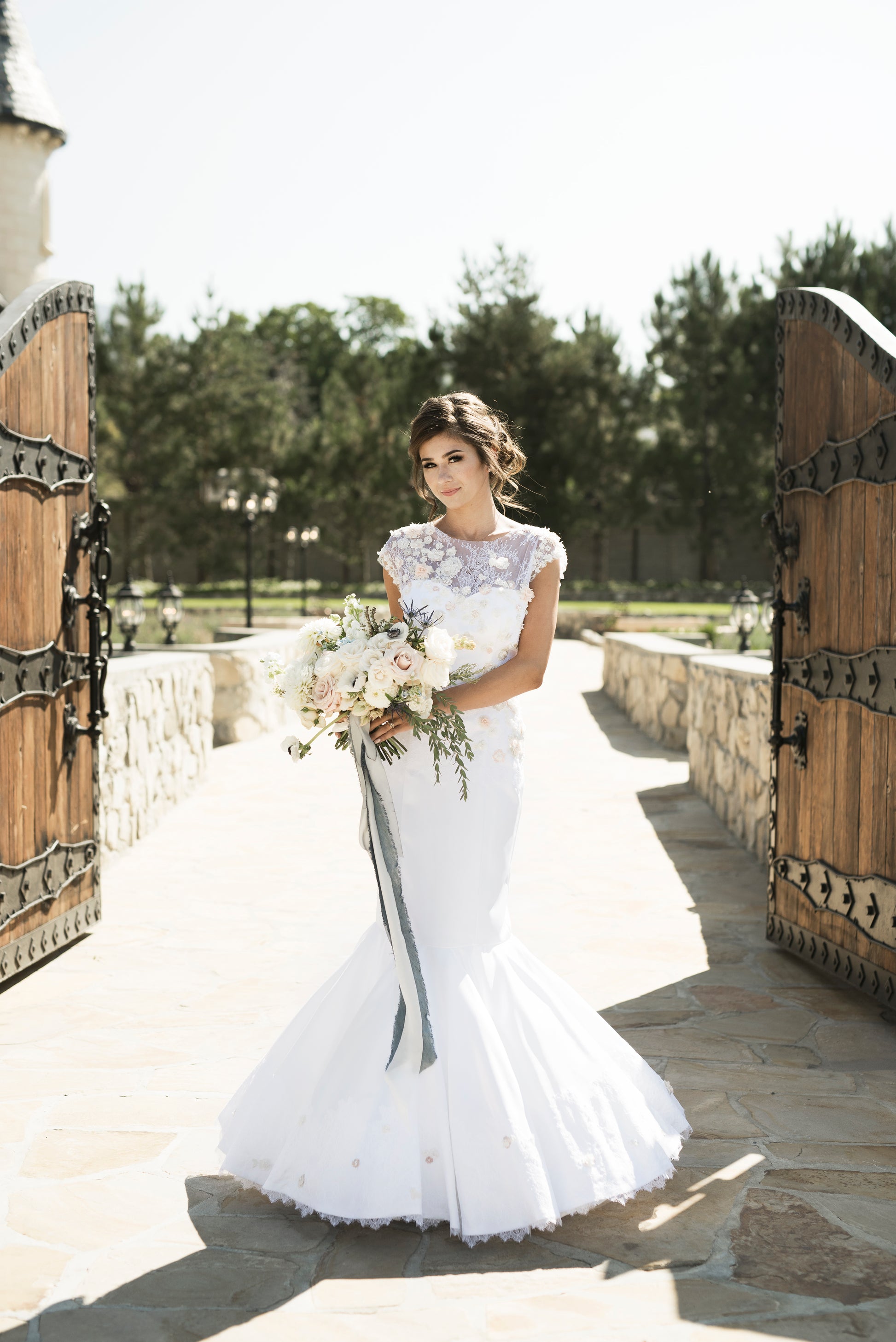 A full front view of the naomi mermaid stretch satin wedding gown, the satin sweetheart neckline has the 3d lace overlay that rises up into a cap sleeve and boat neck overlay.