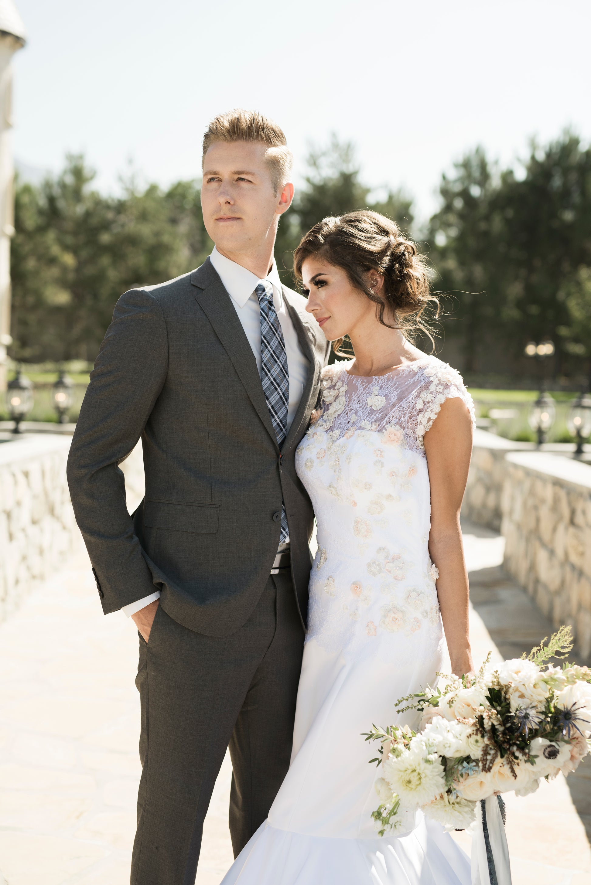 A photo of the 3d lace satin bridal gown, Naomi, a bride stands with her groom in this 3d fashion forward gown