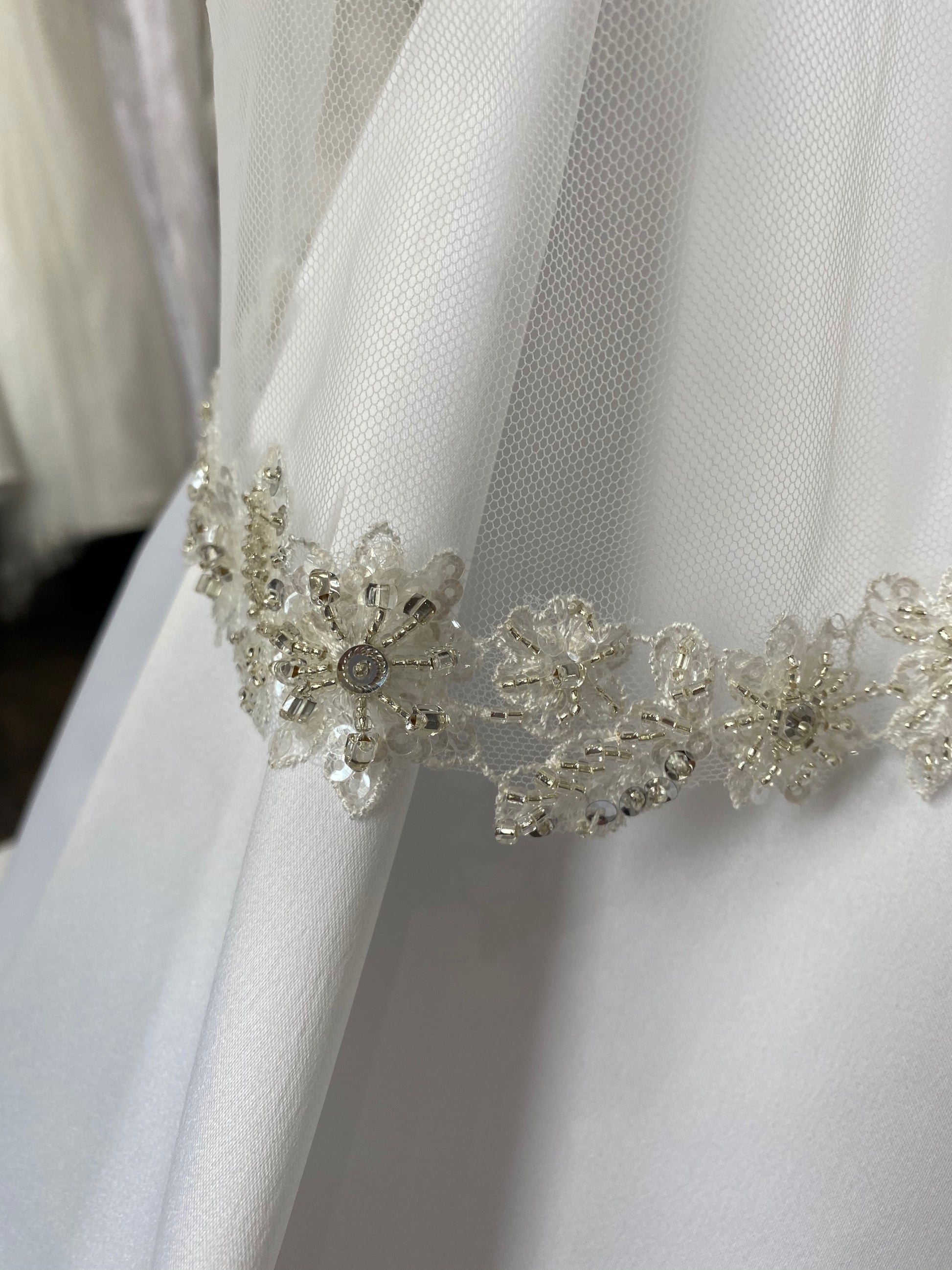 A micro close up of the beaded floral trim on the Haven veil.