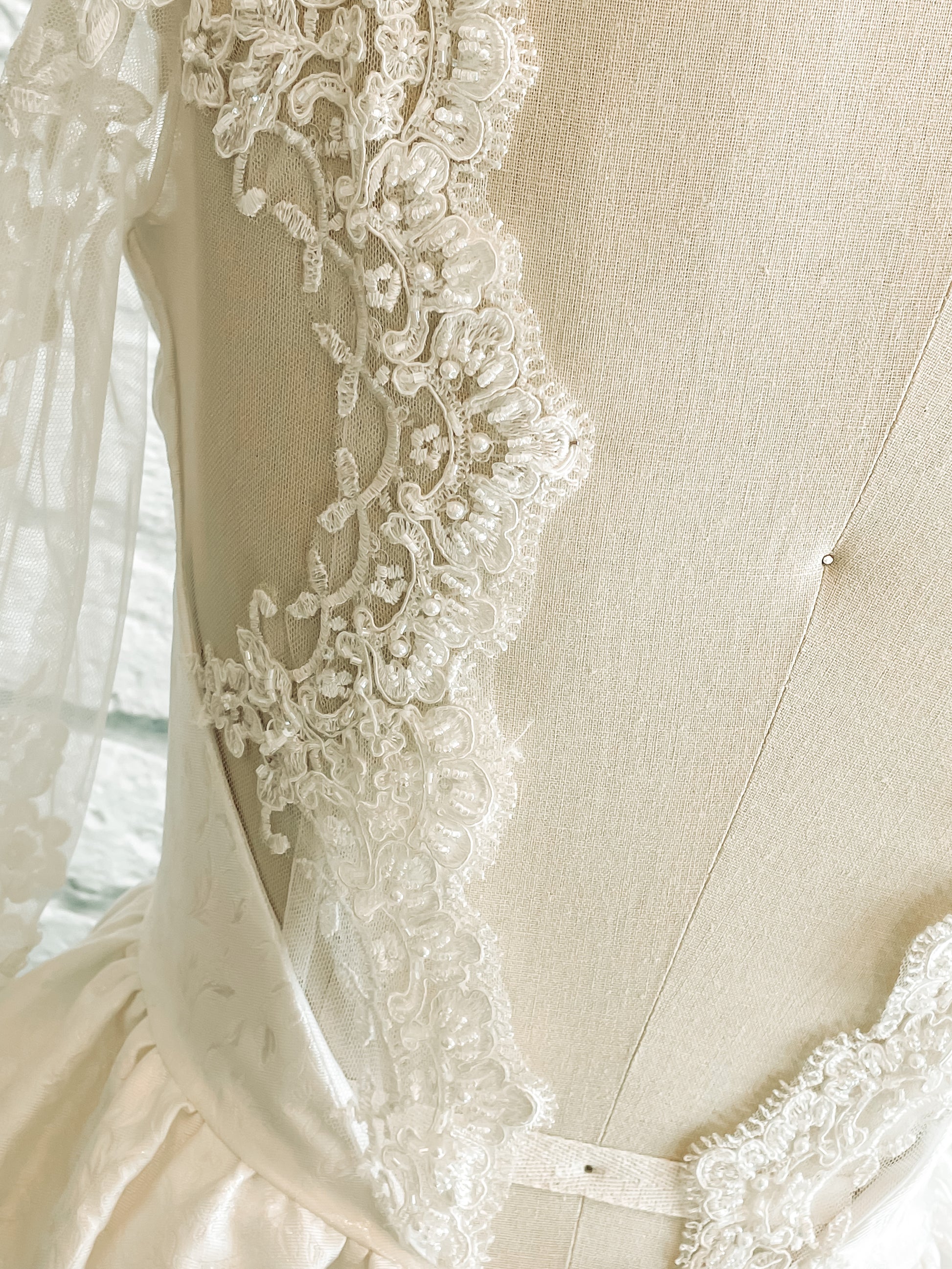 Macro shot of lace scallop along illusion scoop back of the Gemma bodice