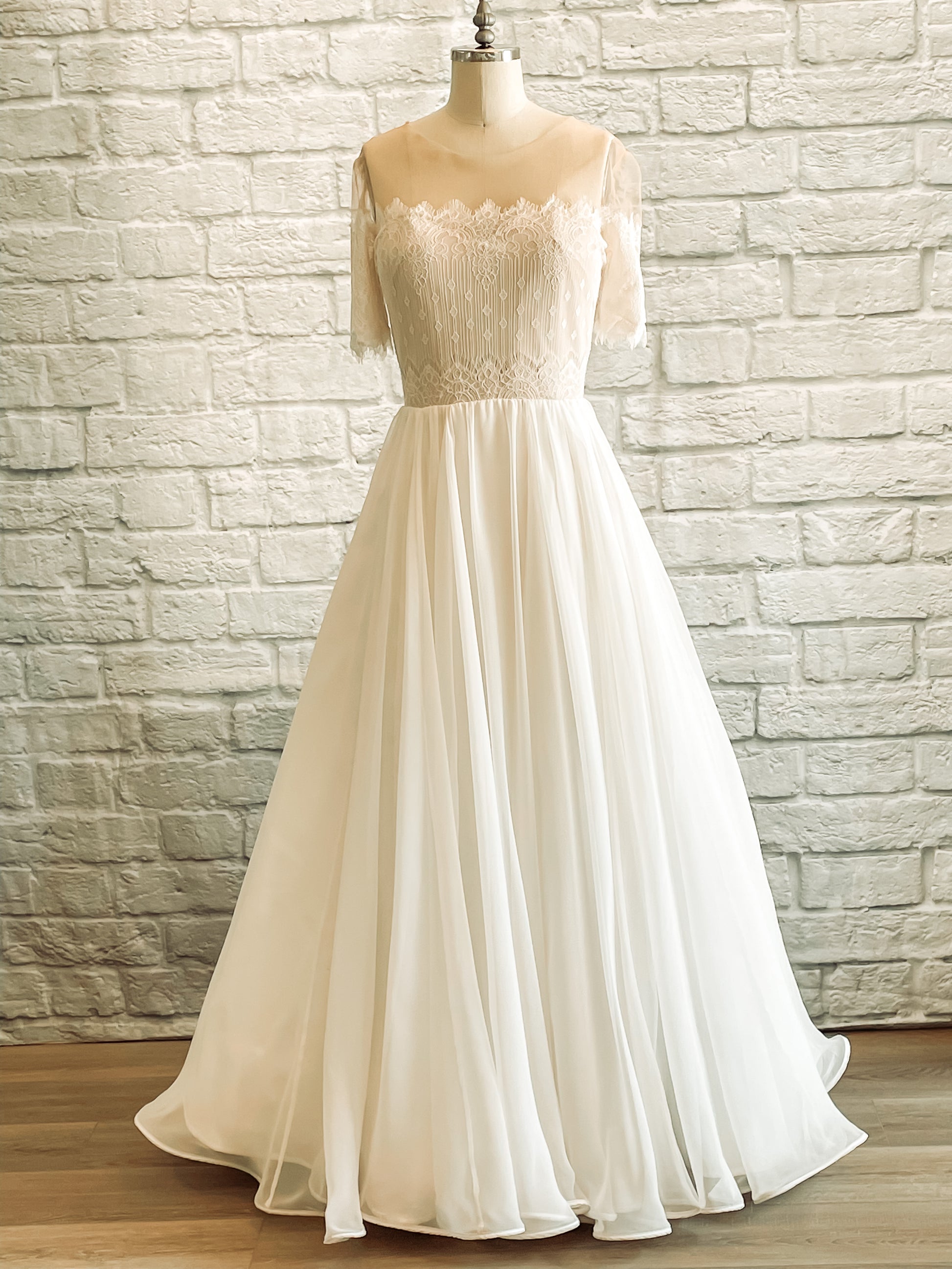 A full front view of the Ronelle dress on a mannequin; the Ronelle wedding gown has a sweetheart lace bodice, eyelash lace, and chiffon ballgown skirt with horsehair hem.