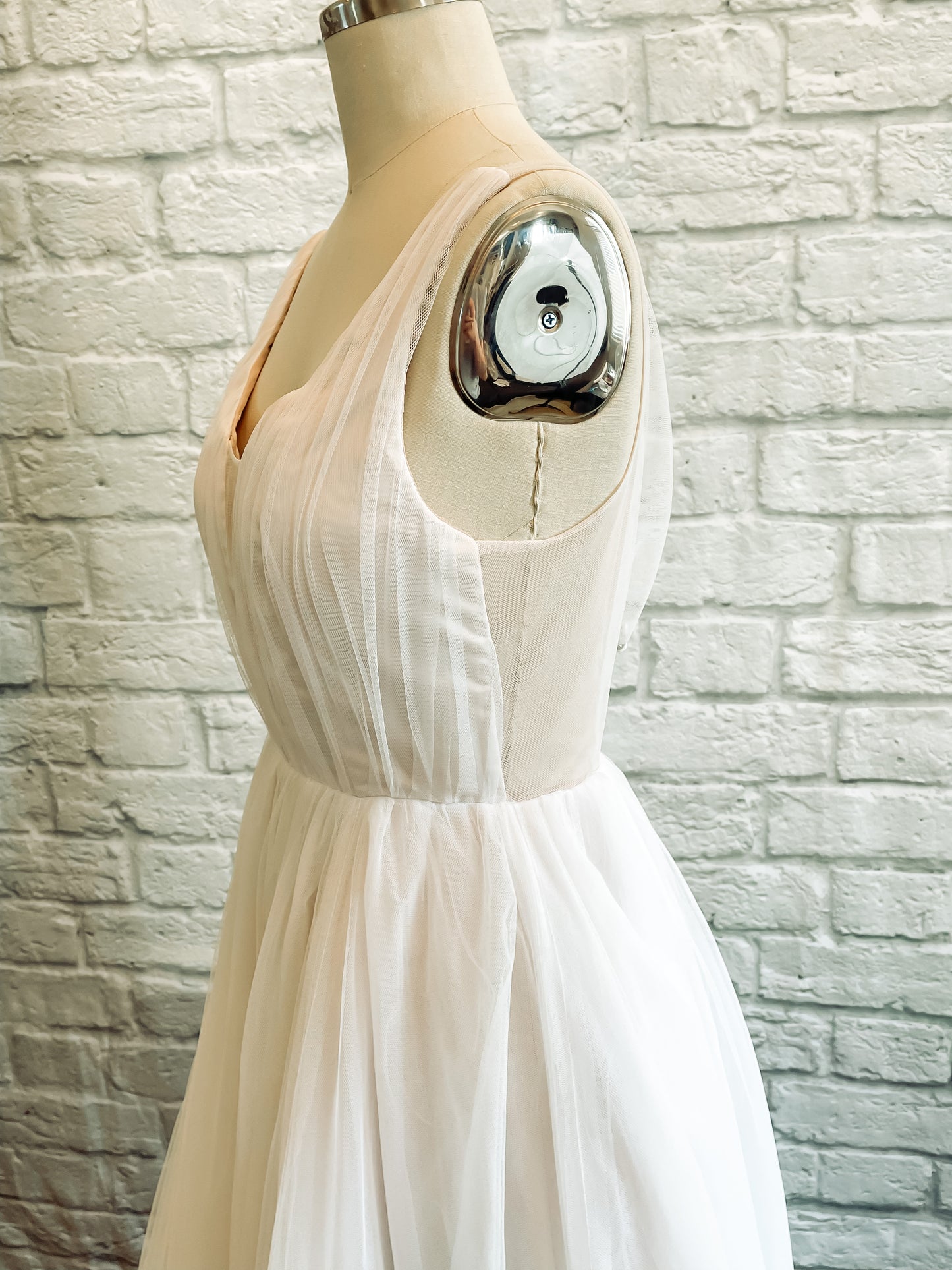 Side view of the persephone wedding gown's bodice, showing the transition between the satin lined portion of the bodie and the sheer back bodice.