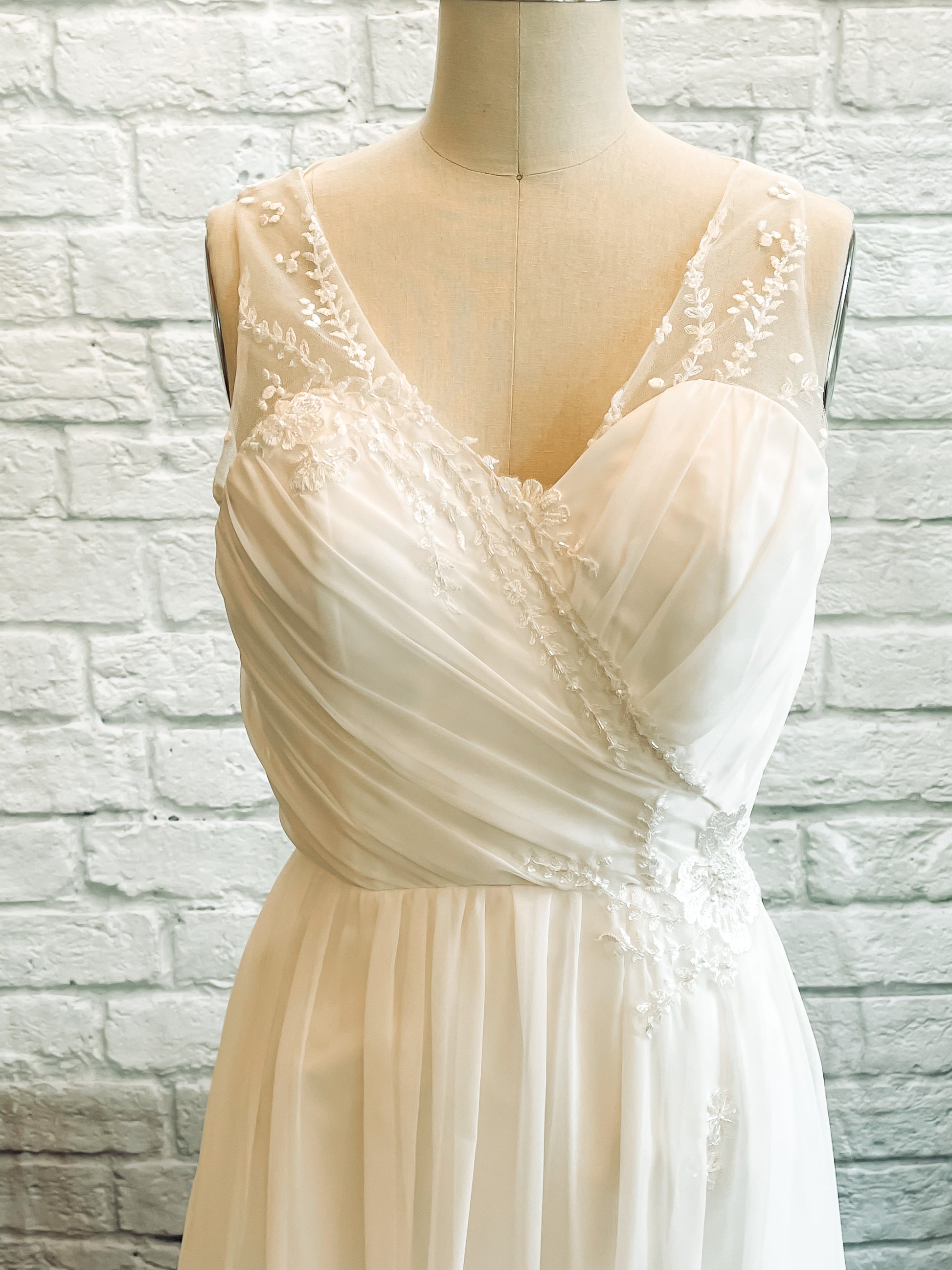 Close-up of beaded floral lace straps  and chiffon bodice on Odette wedding dress