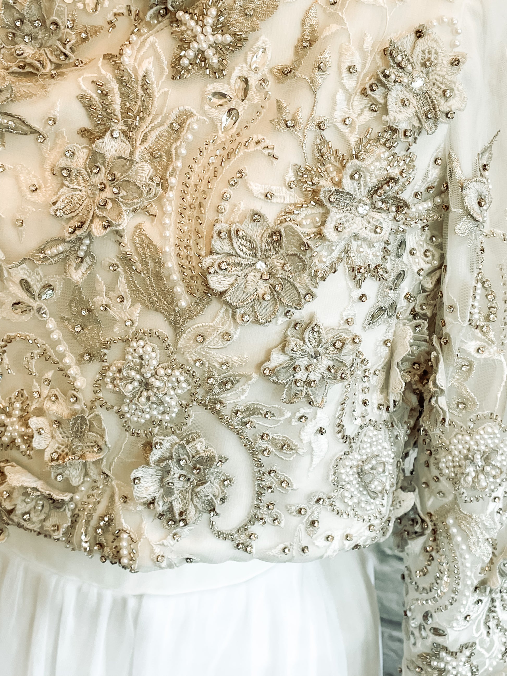 Close-up of the lace bodice detailing with pearls, rhinestones, and 3D petals