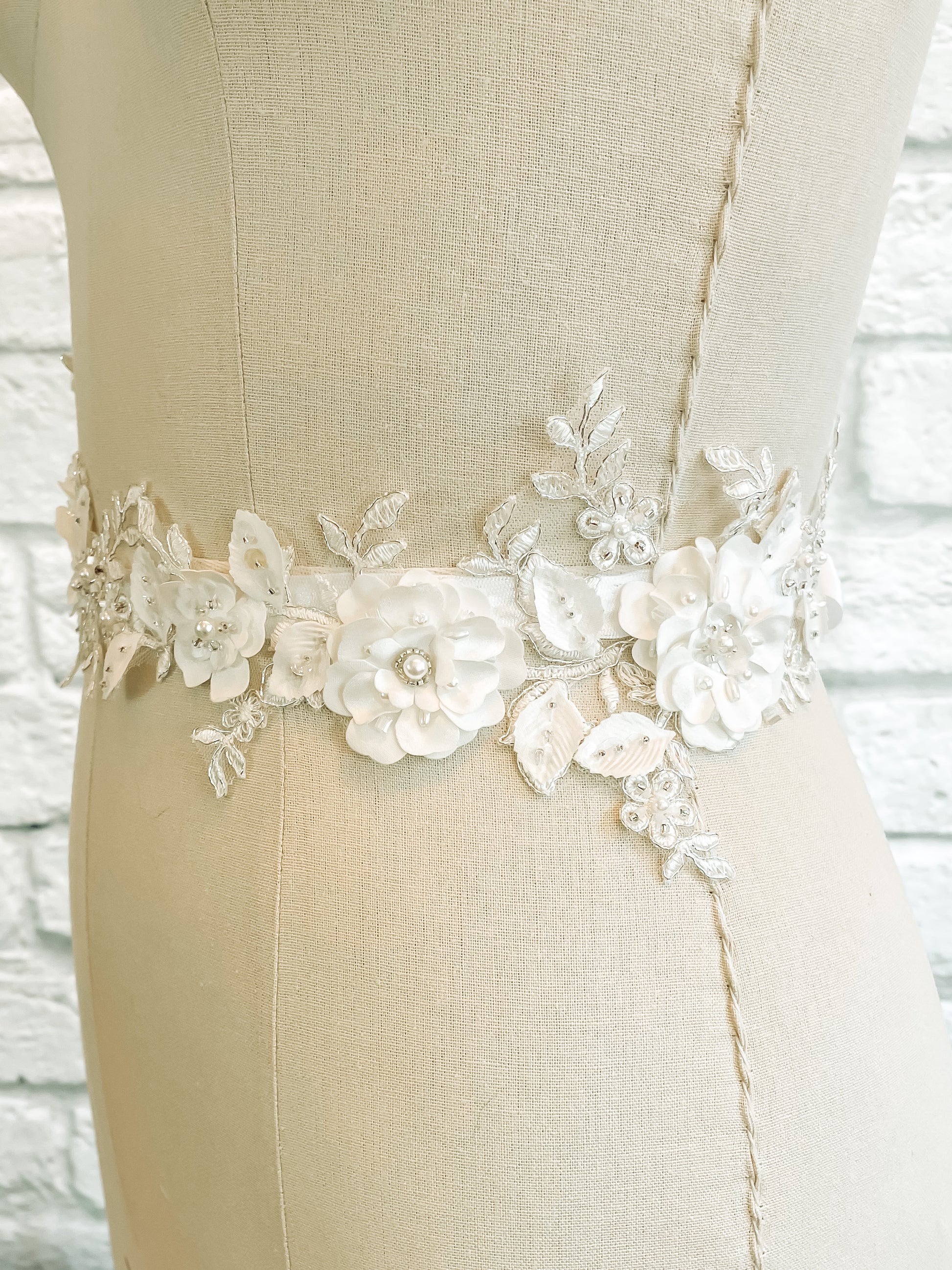 A side view of the Meghan bridal belt with pearl accents and 3d flower petals.