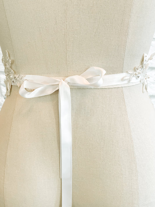 A back photo of the Meghan belt on a mannequin this romantic and whimsical bridal accessory has a ribbon tie with 12" long ties.