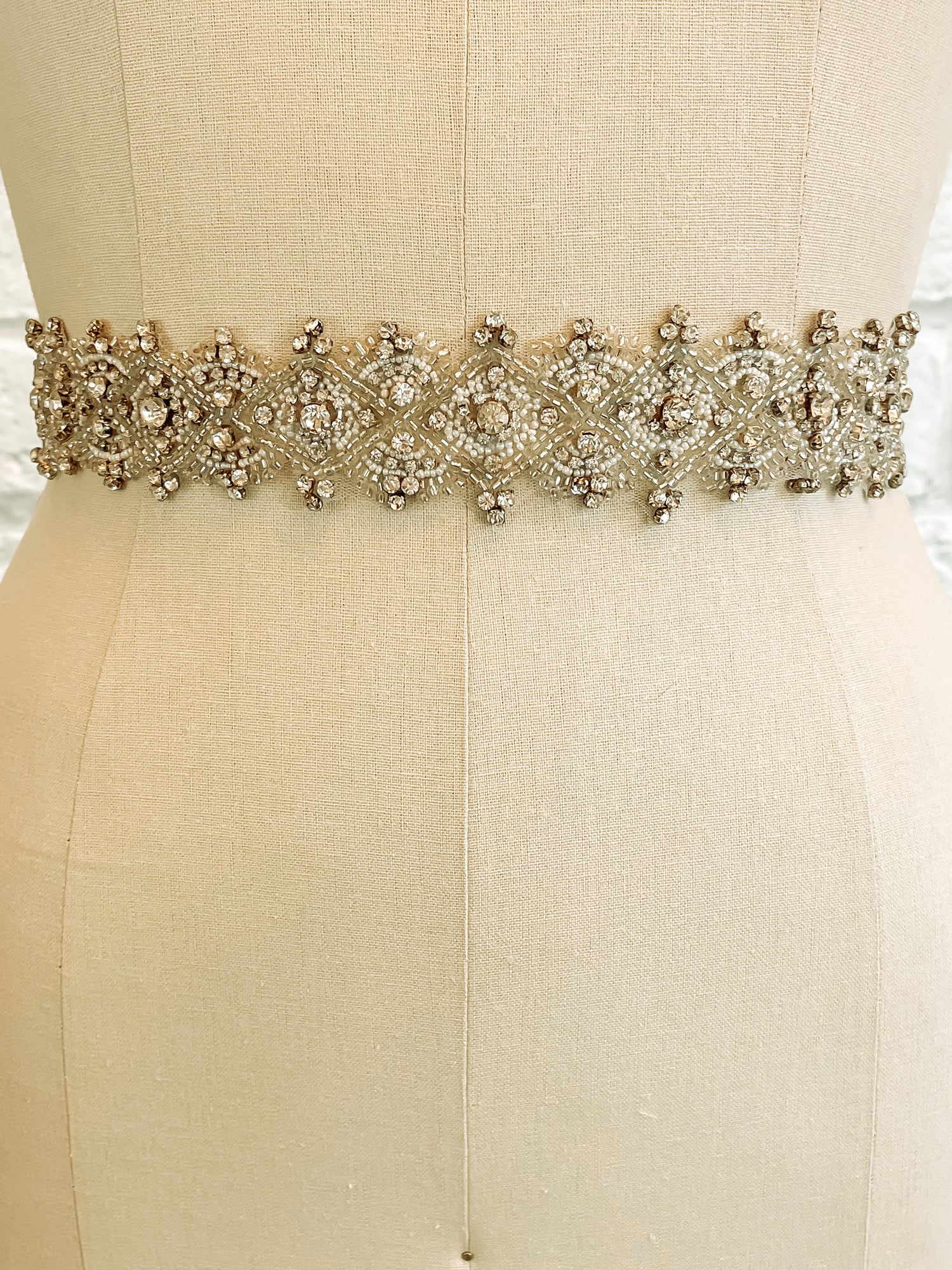 Sasha bridal belt on a mannequin – close-up of diamond rhinestone pattern from the front.
