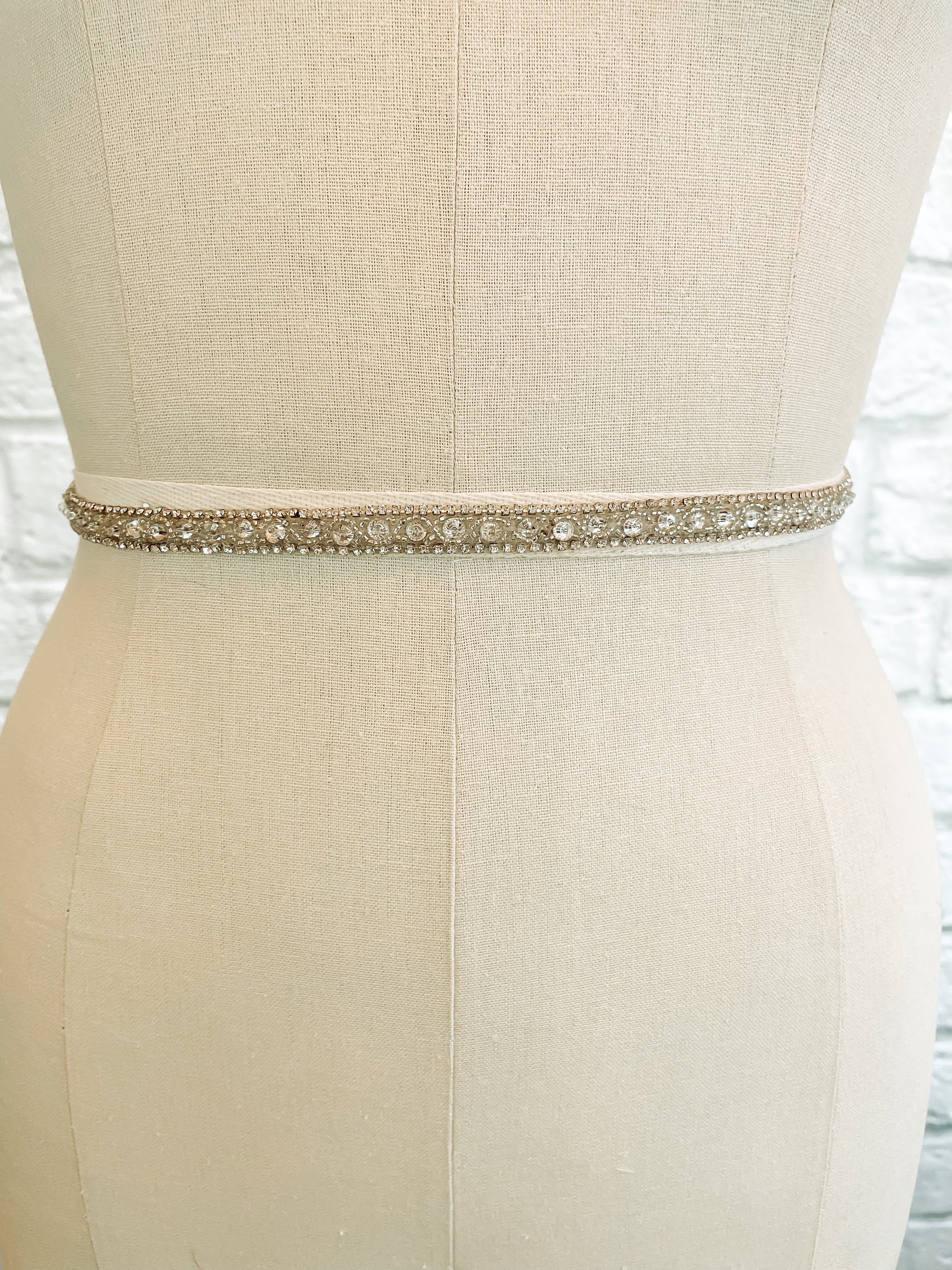 Front Close-up of Kelly skinny rhinestone bridal belt with beading on sheer tulle displayed on a mannequin.