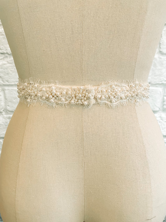 The Millie Bridal belt displayed from the back on a mannequin; showing the continuous beading, scalloping and eyelash details.