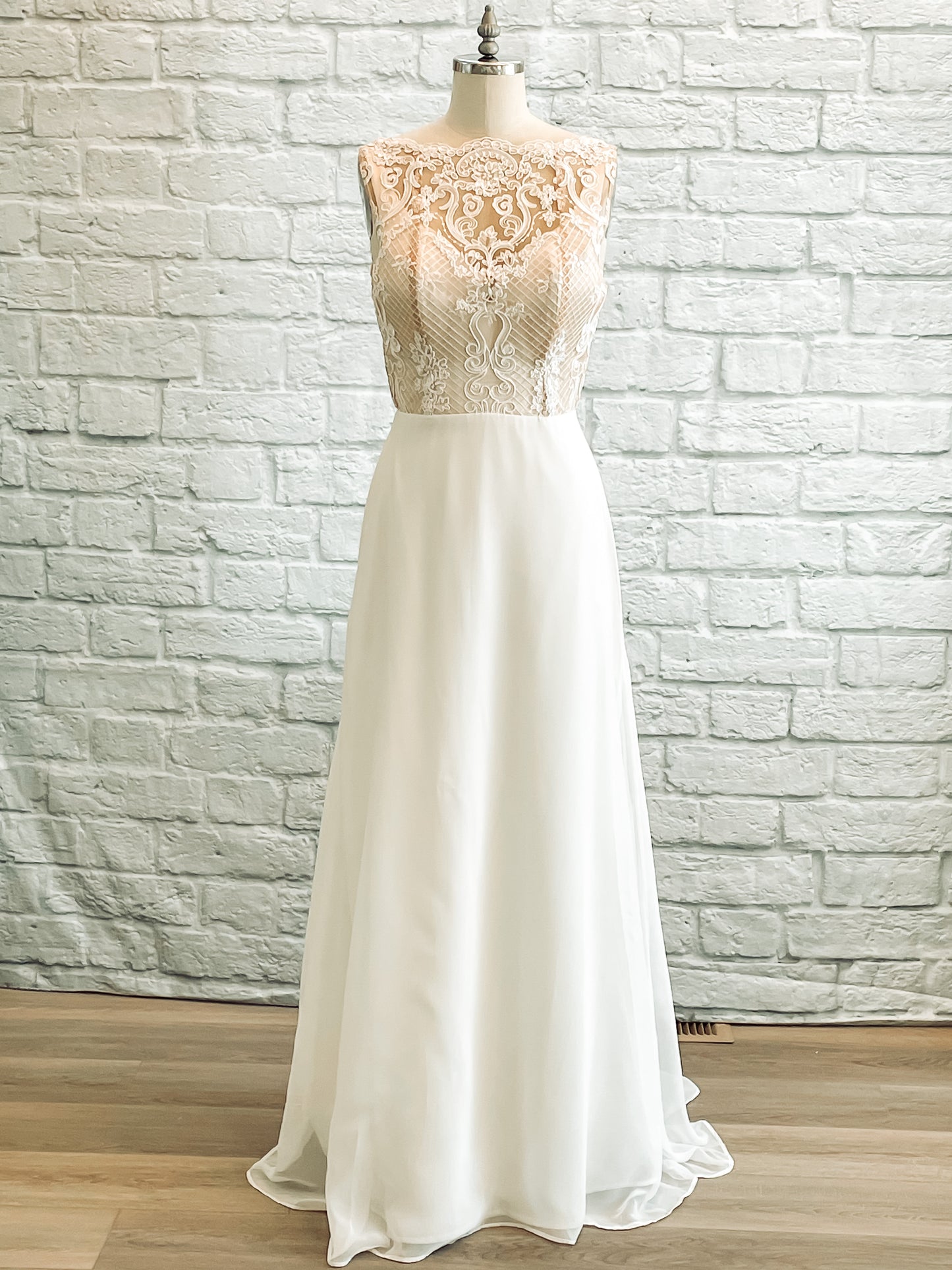 A full length shot from the front of the Winifred gownl with a scalloped high lace neckline and chiffon modified a-line skirt.
