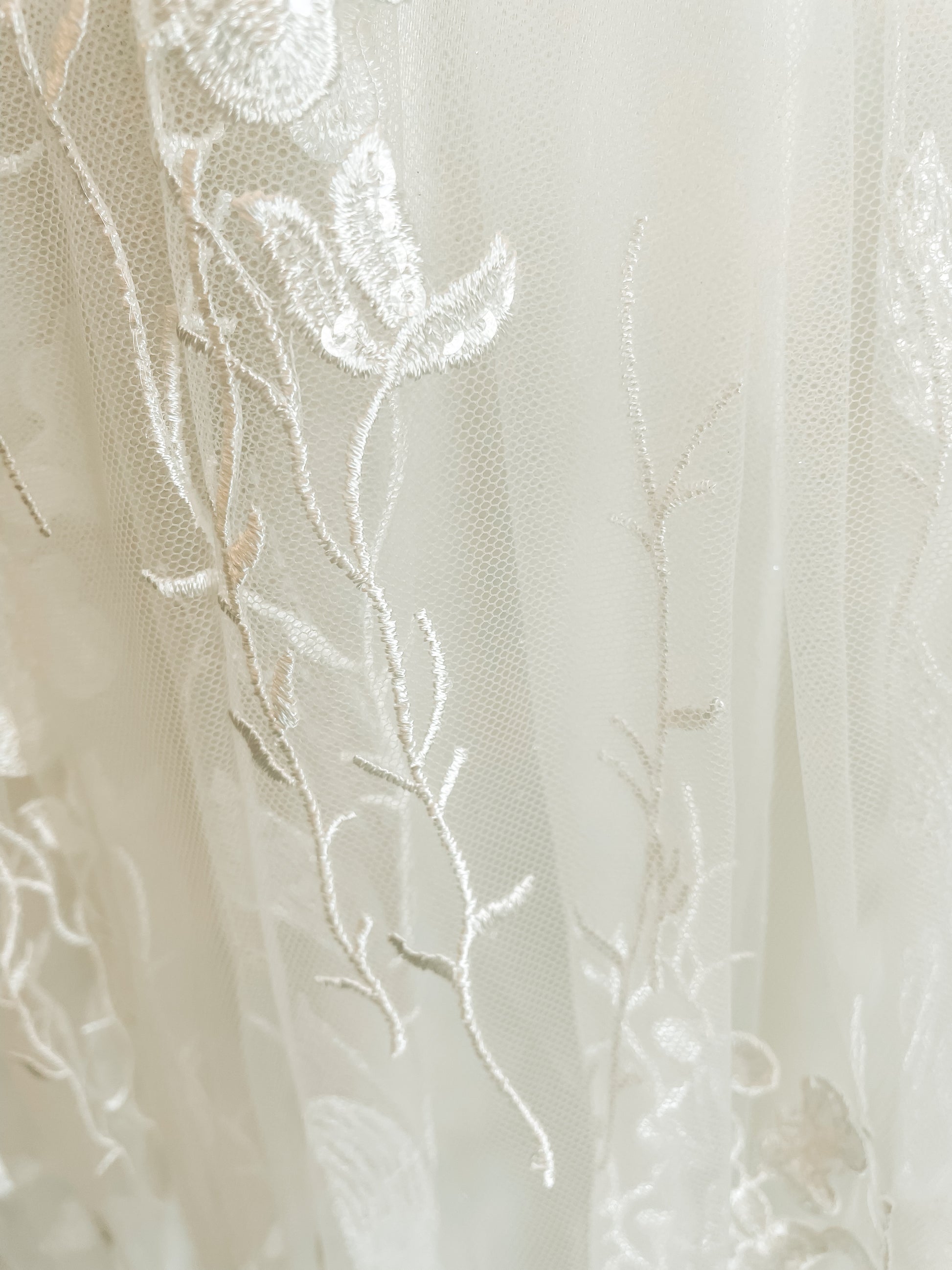 A close up of the Aquatic-inspired fading sequin floral lace on the Rosie bridal gown.