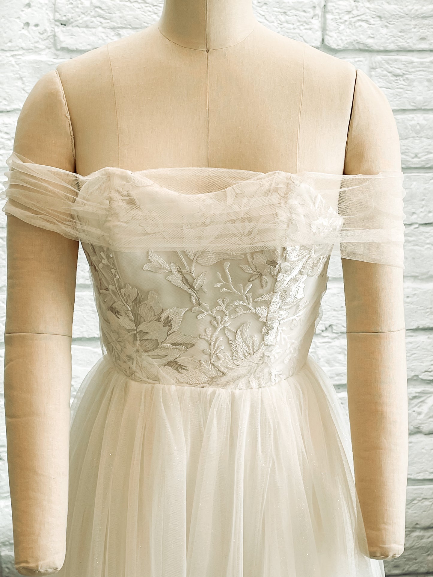 Front bodice view of the penelope gown with a Swooped sweetheart neckline with silver floral lace overlay.