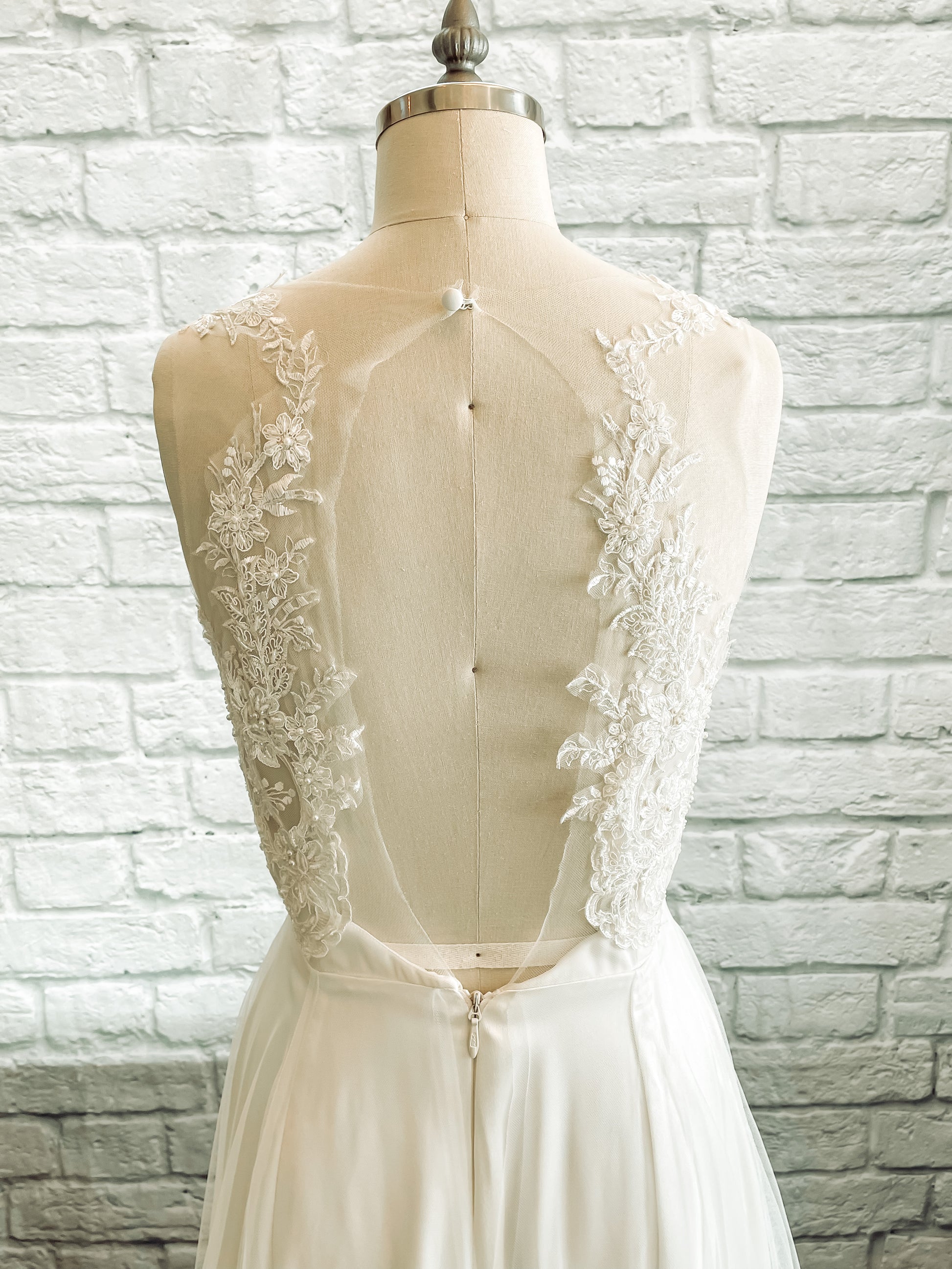 Close up of the back bodice of Marie, back detail of lace framing large illusion keyhole that is open from the neck to the waist.
