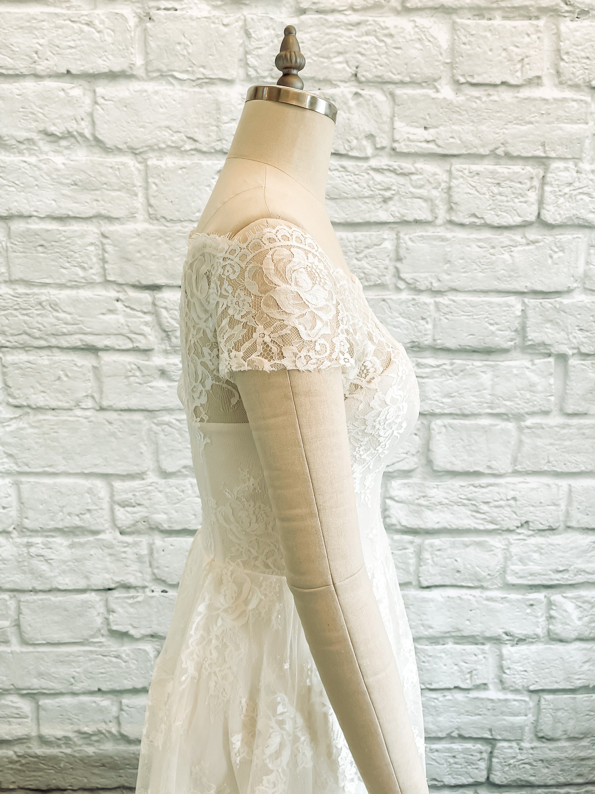 A side view of Serafina and her sheer lace sleeves with a scalloped top edge.