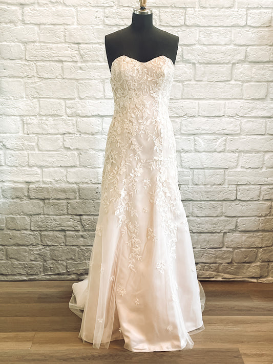 A full front view of the Sawyer wedding gown on a mannequin, Sawyer has a trumpet silhouette and is shown in Antique Rose with beaded lace.