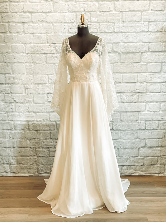 Front view of mannequin in Novelli gown with sweetheart neckline and chiffon skirt overlay