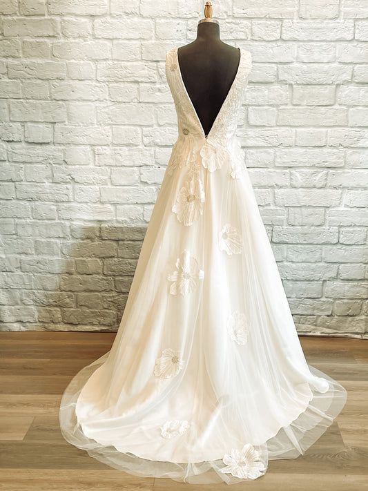 Full back view of the poppy gown; it has a Low V-back with cascading floral appliqués on tulle skirt.