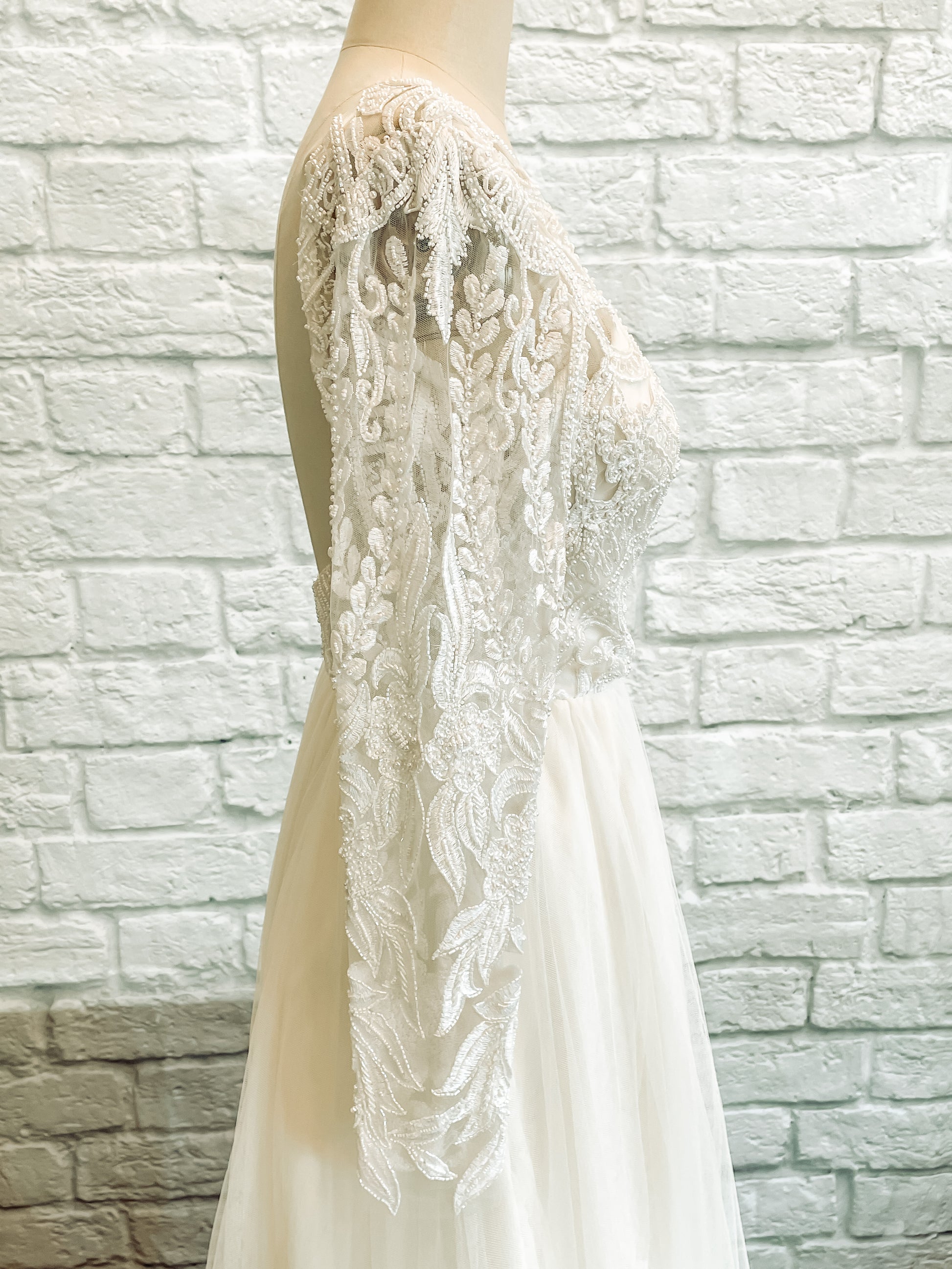 Side angle of the reflective sleeve pattern on the long lace sleeves of Farrah.