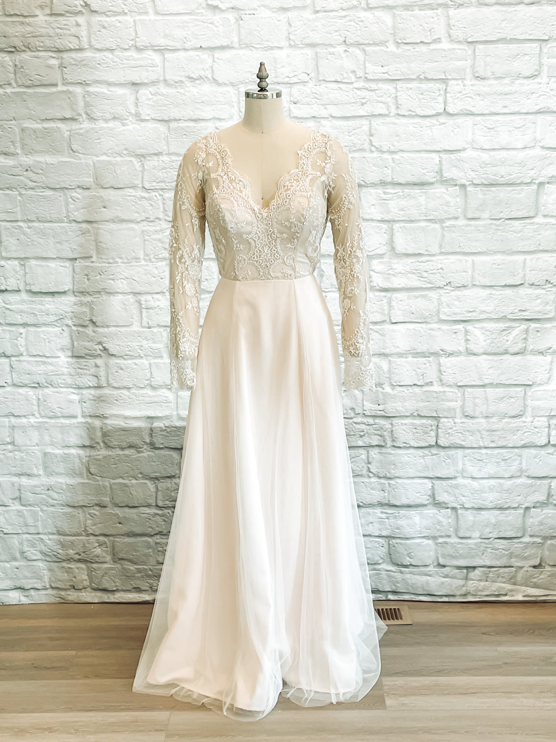 Full-length front view of the Eivissa gown on mannequin, showing beaded lace bodice, long sleeves, and soft tullé A-line skirt.