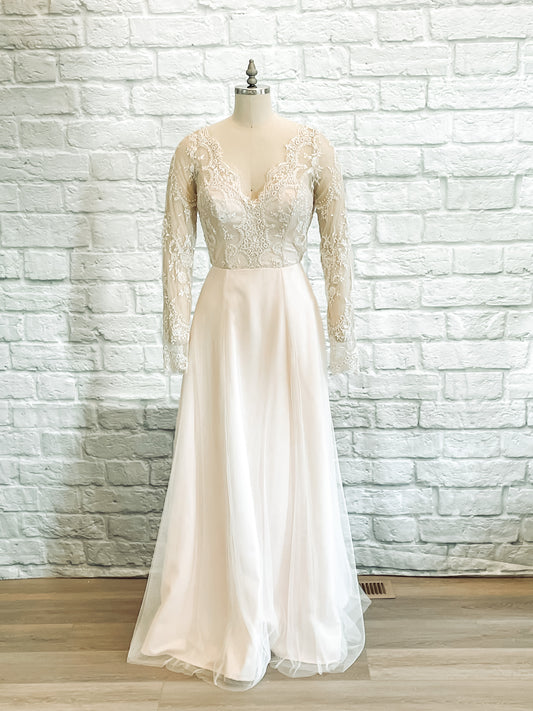Full-length front view of the Eivissa gown on mannequin, showing beaded lace bodice, long sleeves, and soft tullé A-line skirt.
