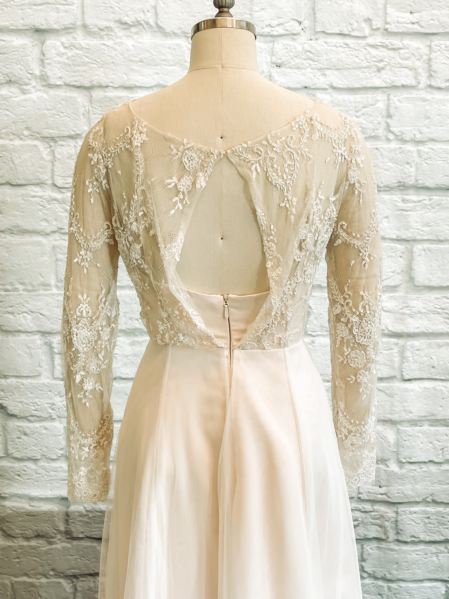 Mannequin turned away, revealing the boat neck lace back and soft closure at the top of the bodice.