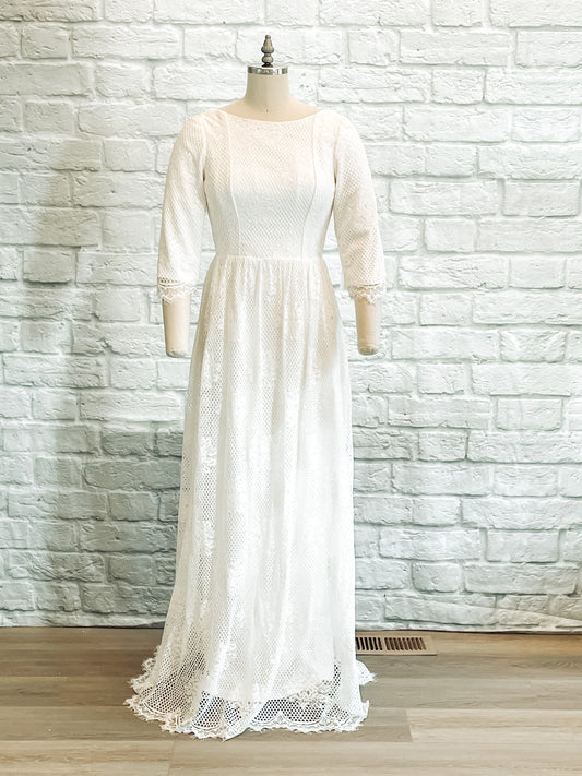 Avabelle wedding gown displayed on a mannequin, featuring a boat neckline, fitted lace bodice, and modified A-line silhouette with soft lace overlay.