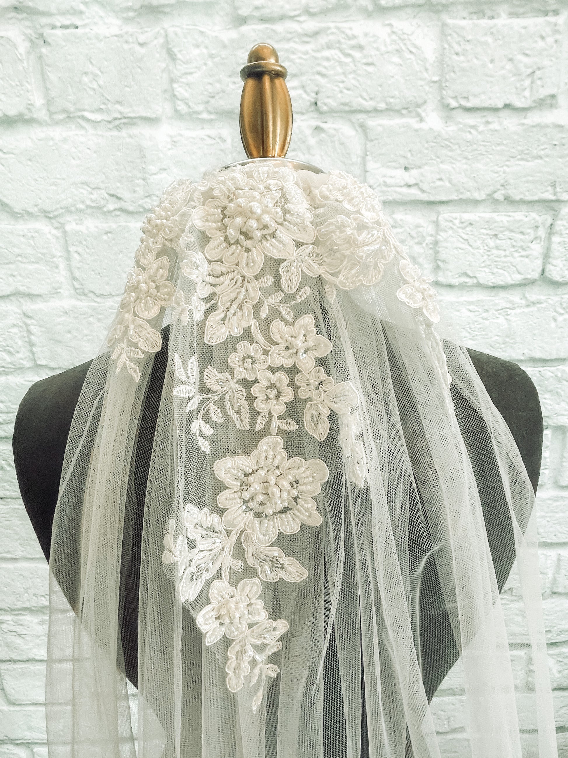 Beaded lace wedding veil close-up of the floral lace at the top of the Sharon veil. The veil is displayed on a mannequin.