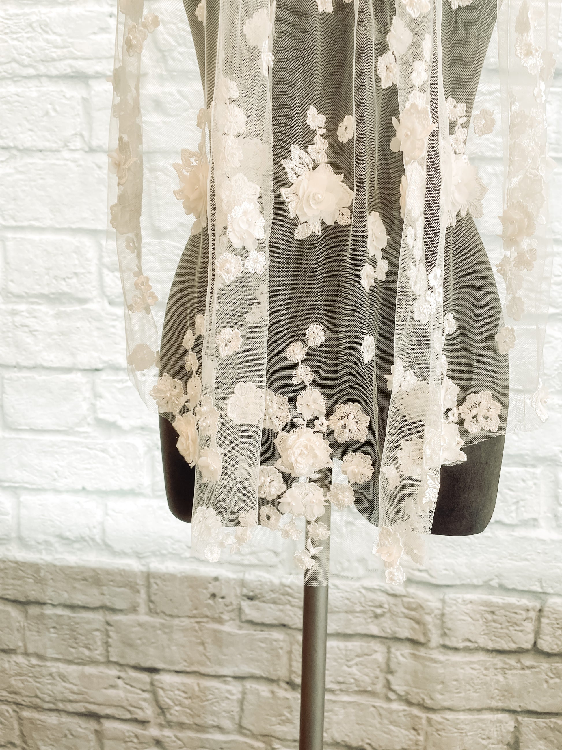 A close up view of the bottom of the Tiana veil with the 3d floral details and pearl and sequin additions.