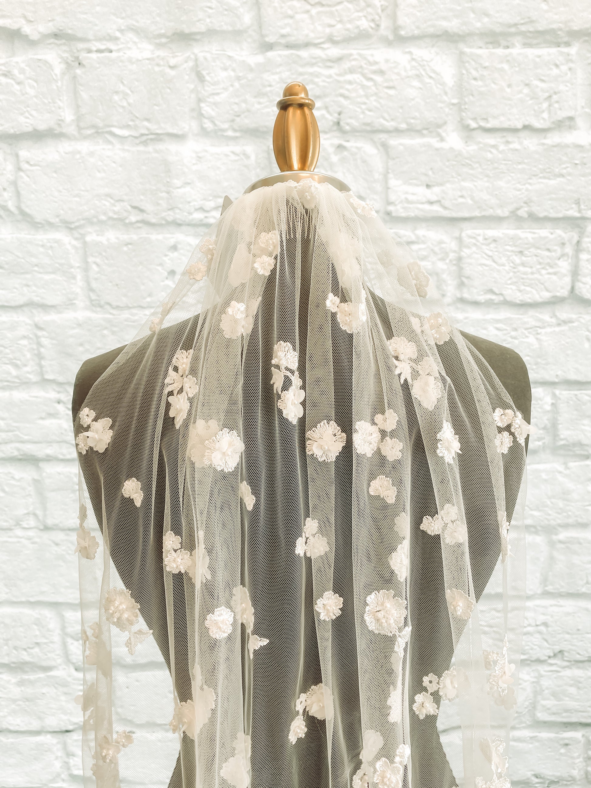 An upclose view of the Tiana veil with 3D floral appliqués and pearls.
