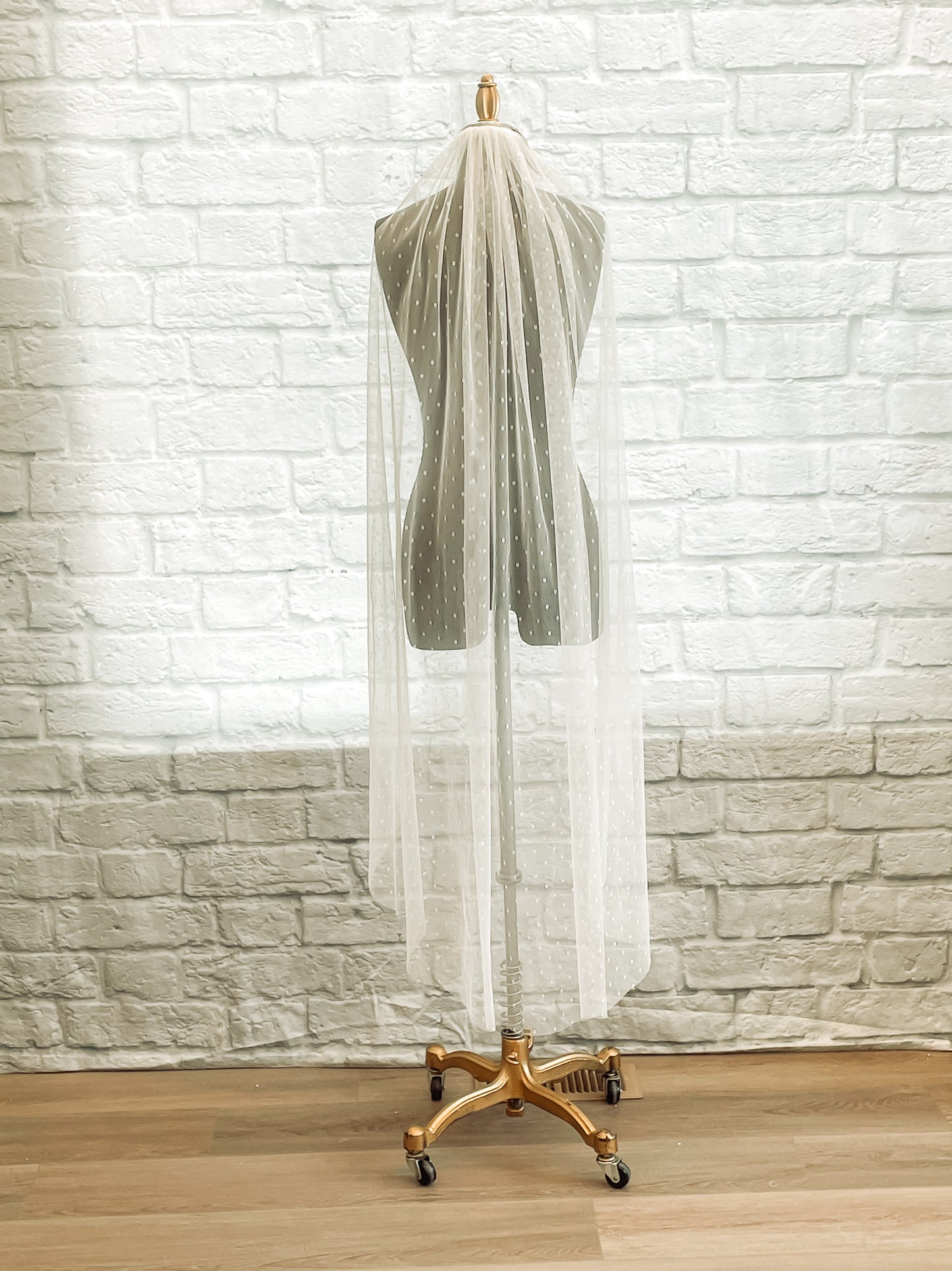 Lightweight dotted veil with comb, scalett has been displayed on a mannequin. This veil is being shown in a waltz length.