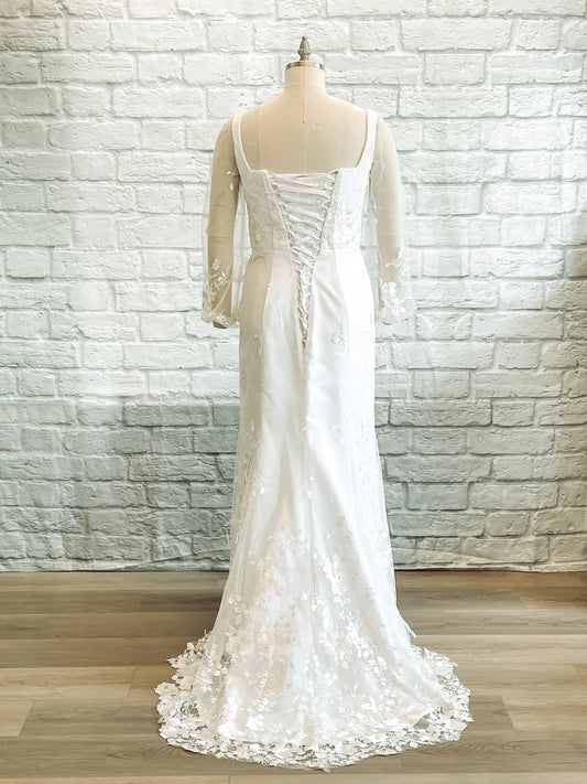 Full length back shot of the Violet gown on a mannequin; featuring the Lace-up corset and floral lace train.
