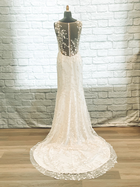 Full back view of the Lorien wedding gown with low cut scoop back, pearlized button closure, and long train.
