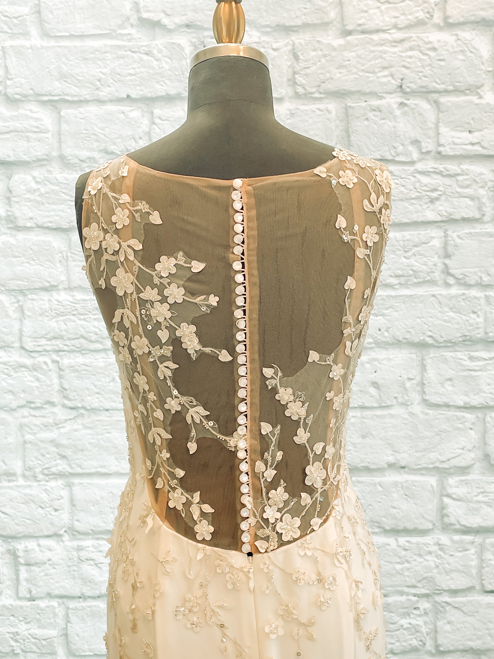 A close up view of the back bodice of Lorien,  showing the Illusion lace growing across shoulders and down the back with pearlized buttons.