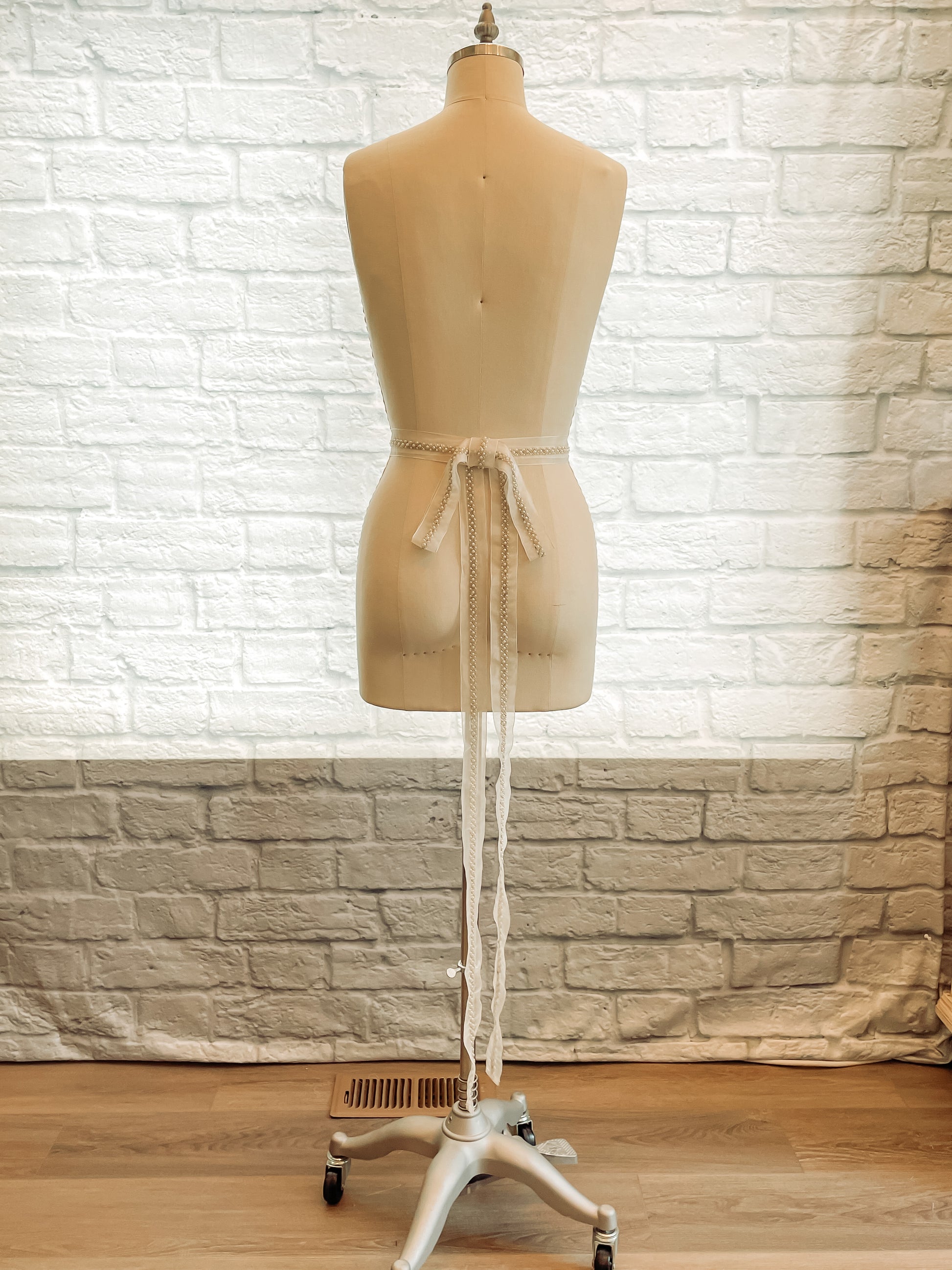 Back view of the fleur belt with the bow and tails in view. You can see how long the tails go before ending. The belt is shown on a mannequin.