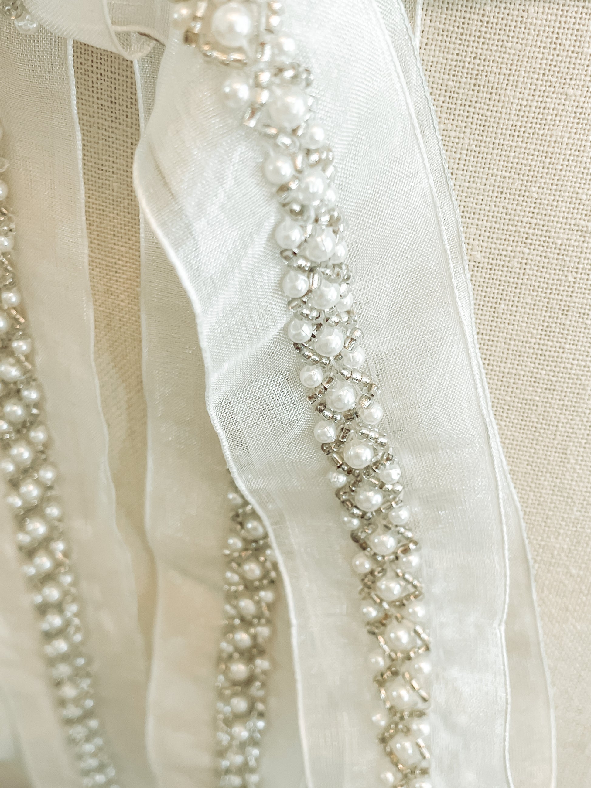 Close-up of silver and pearl diamond pattern on sheer organza.
