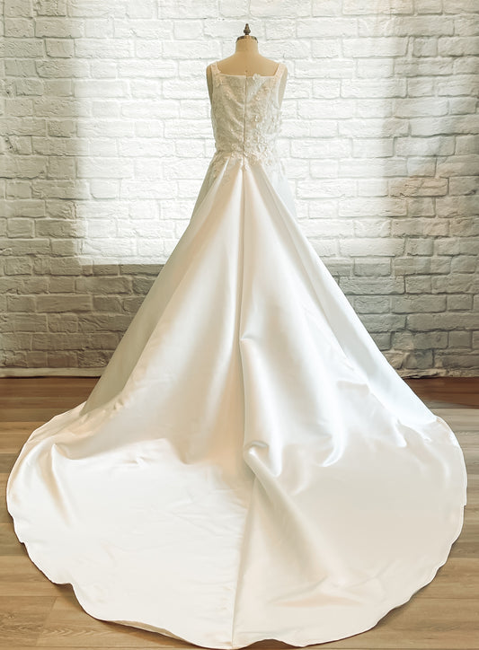 The Sabina gown is on a mannequin; showing the full back it has a square back neckline and extra-long duchess satin train.