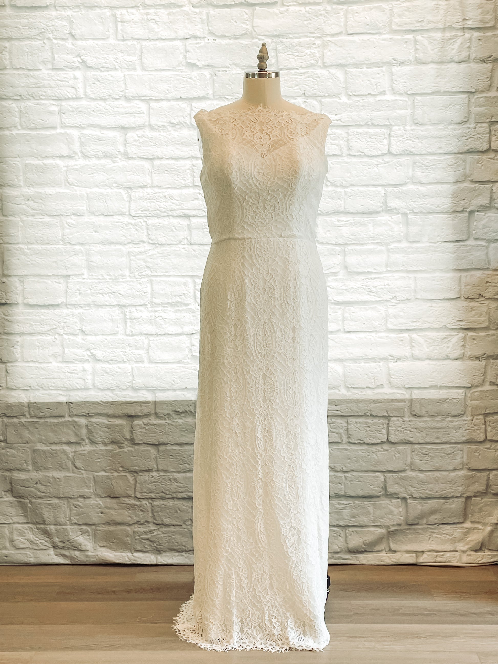 Front view of the Blair gown displayed on a mannequin, showcasing its all-lace overlay, boat neckline, and figure-hugging column silhouette.