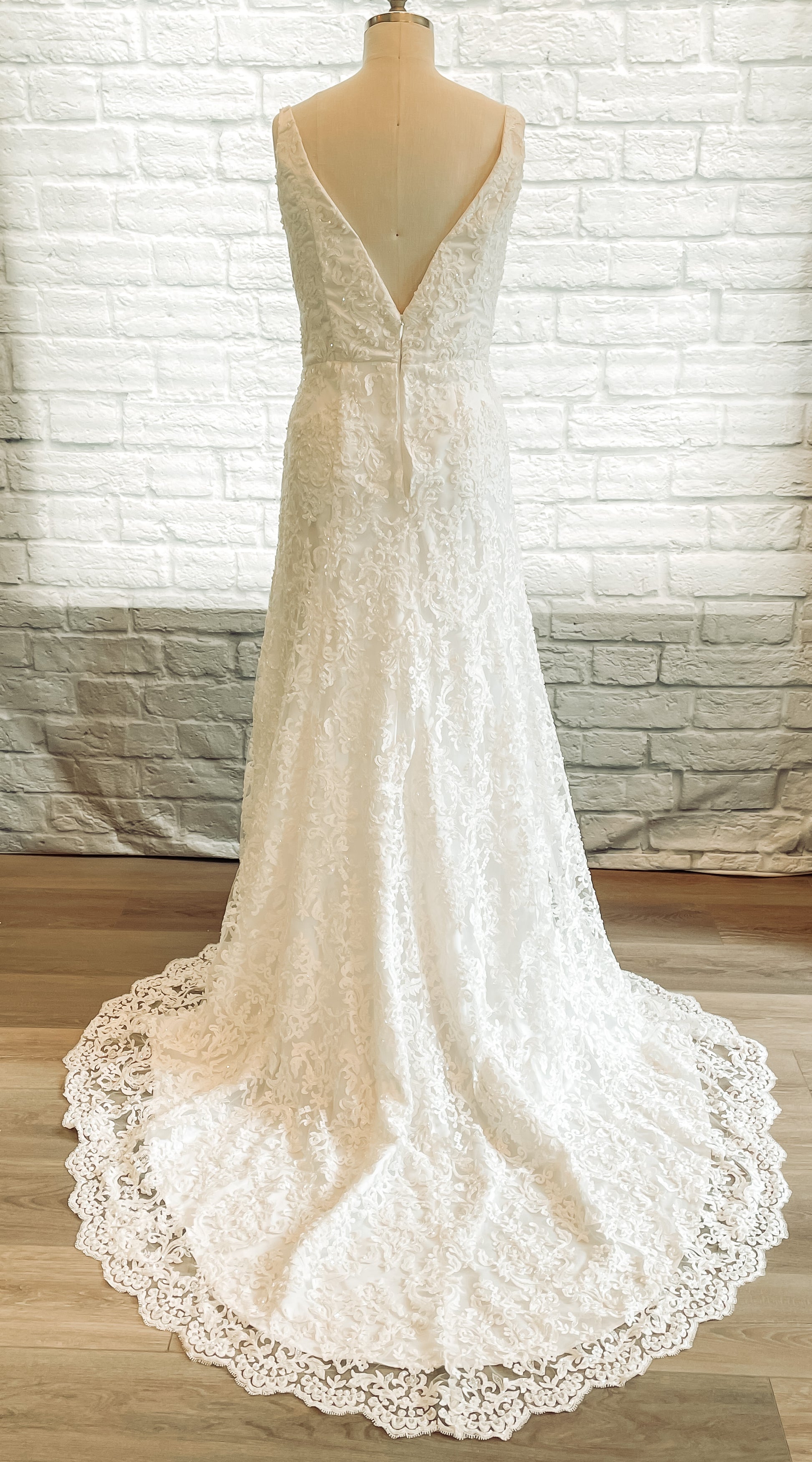 Full back view of the Margaret; a V-back beaded lace gown with scalloped train, shown here in Ivory.
