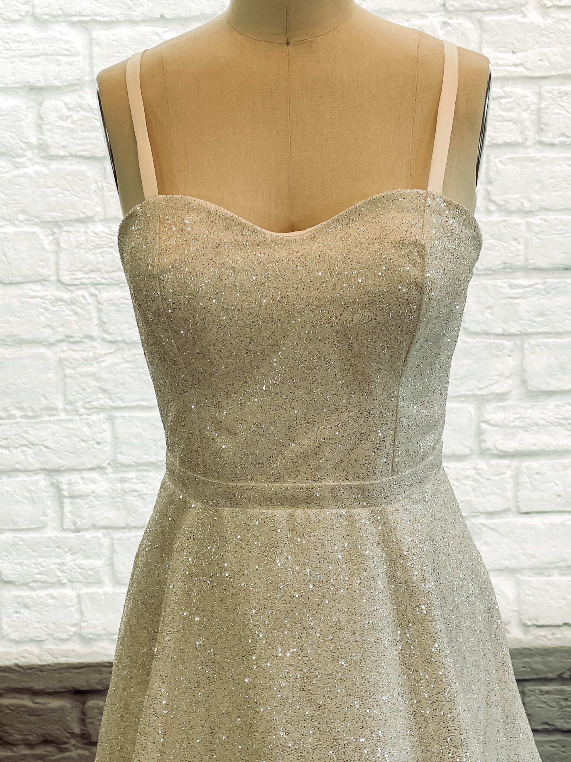 Close-up of the sweetheart neckline and wider spaghetti straps on the glitter bodice