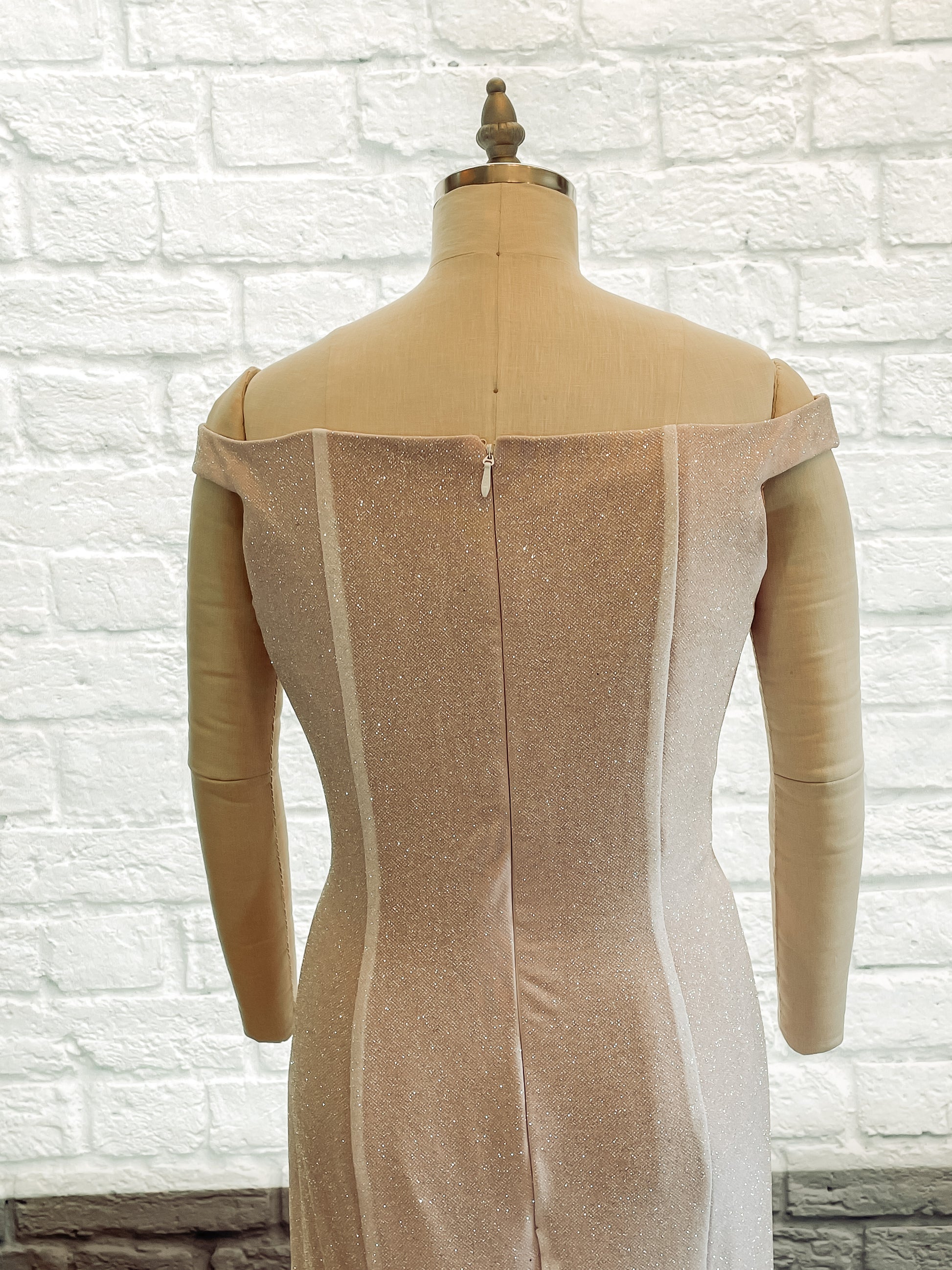 Close up of the back bodice of the Alora gown on a mannequin. Made from a stretch crepe glitter fabric.
