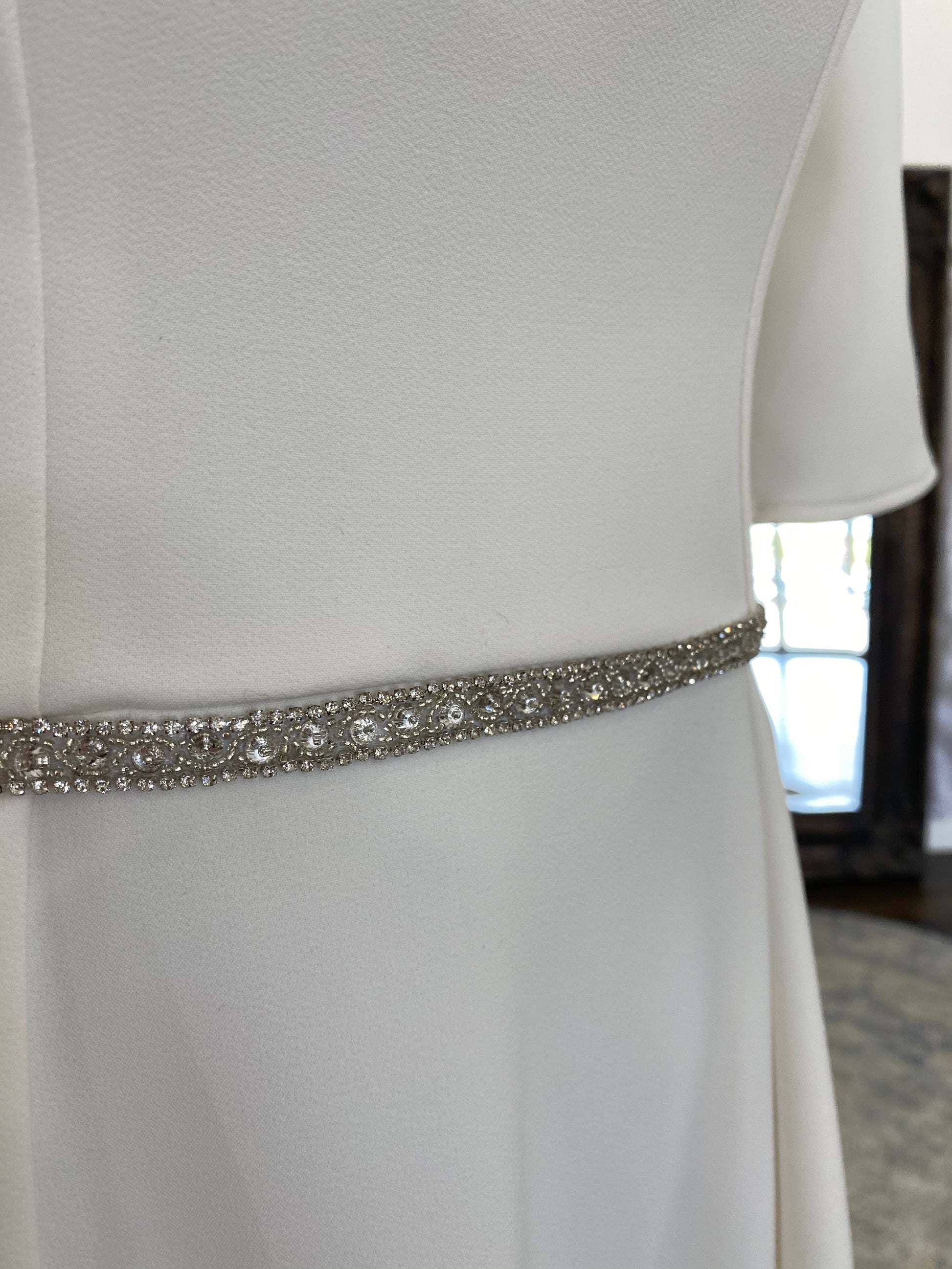 Mannequin wearing slim Kelly belt at the waist of a crepe wedding dress