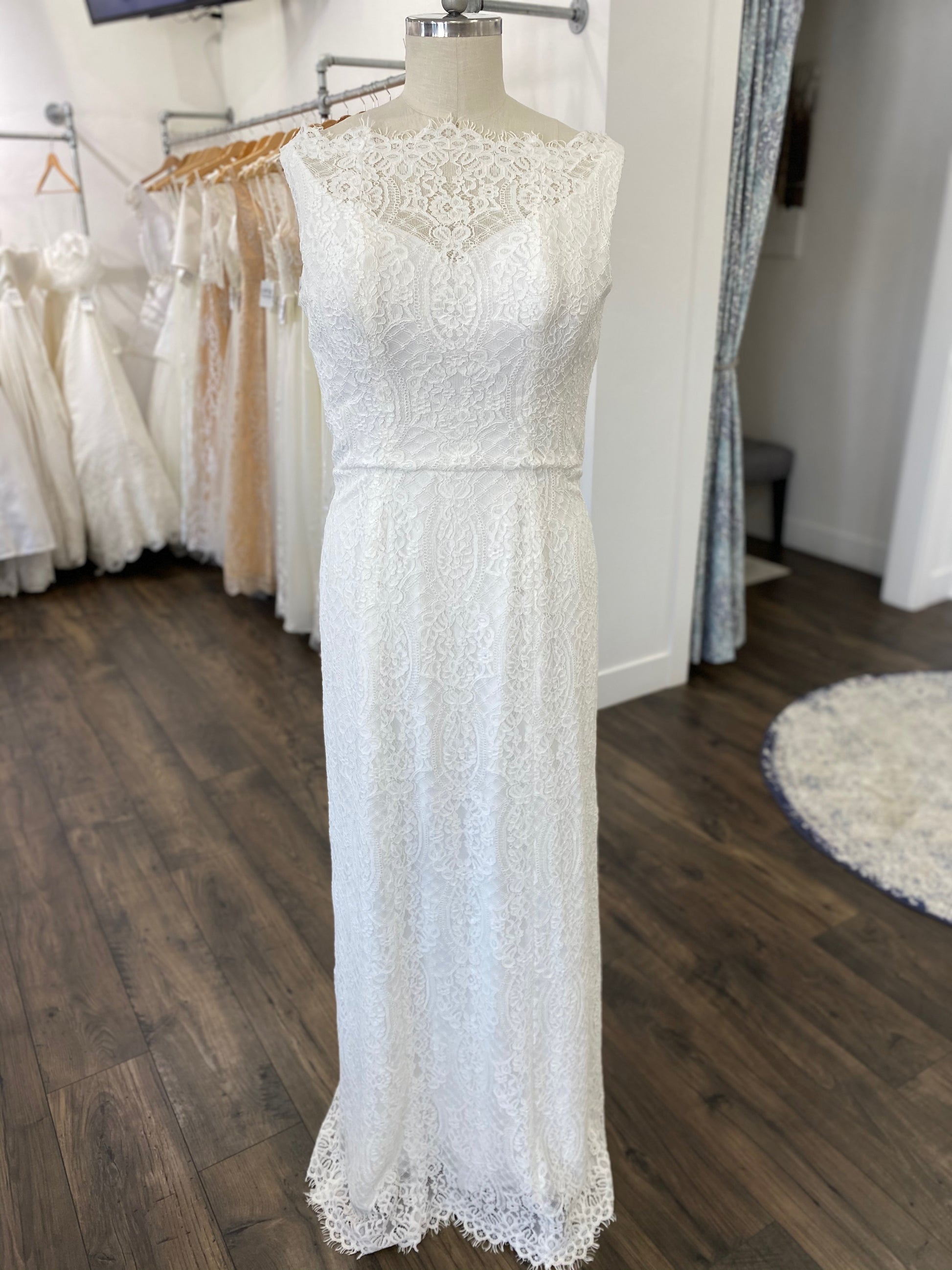 Full-length image of the Blair gown displayed on a mannequin, capturing the elegant simplicity of the floor-length column silhouette with no train.