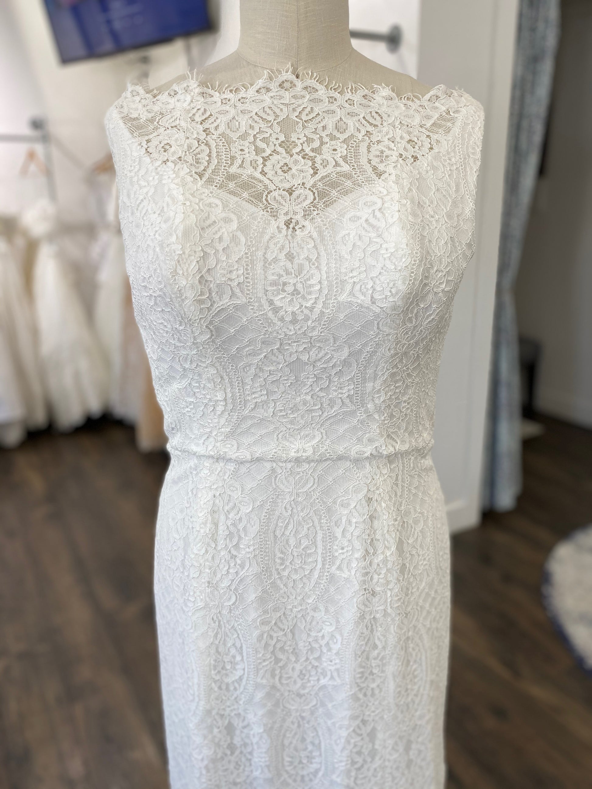 Detail of the front bodice and floral lace overlay on the Blair gown, showing the mix of vertical trellis lines, floral patterns, and diamond lacework.