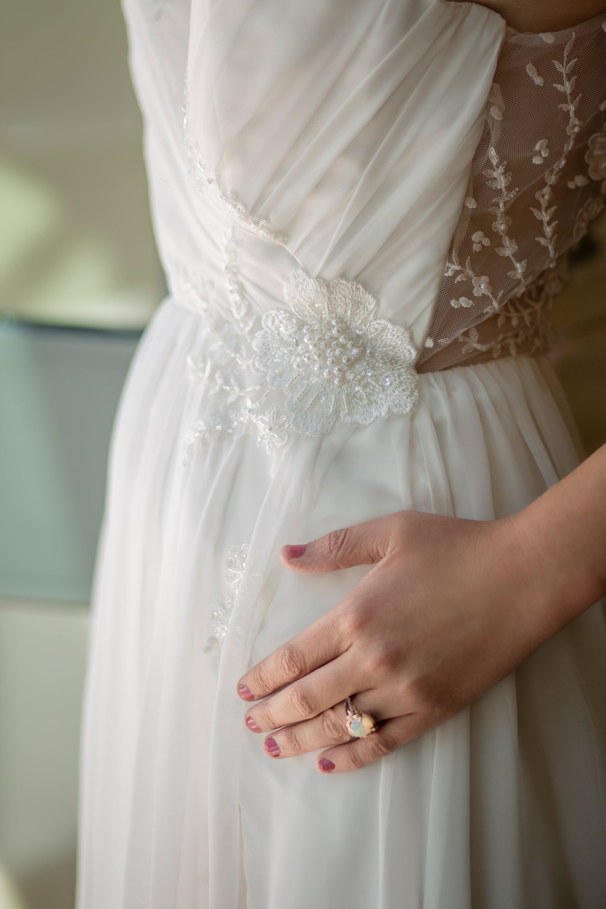 Close up side profile of Odette dress highlighting cross-body draping and beaded floral