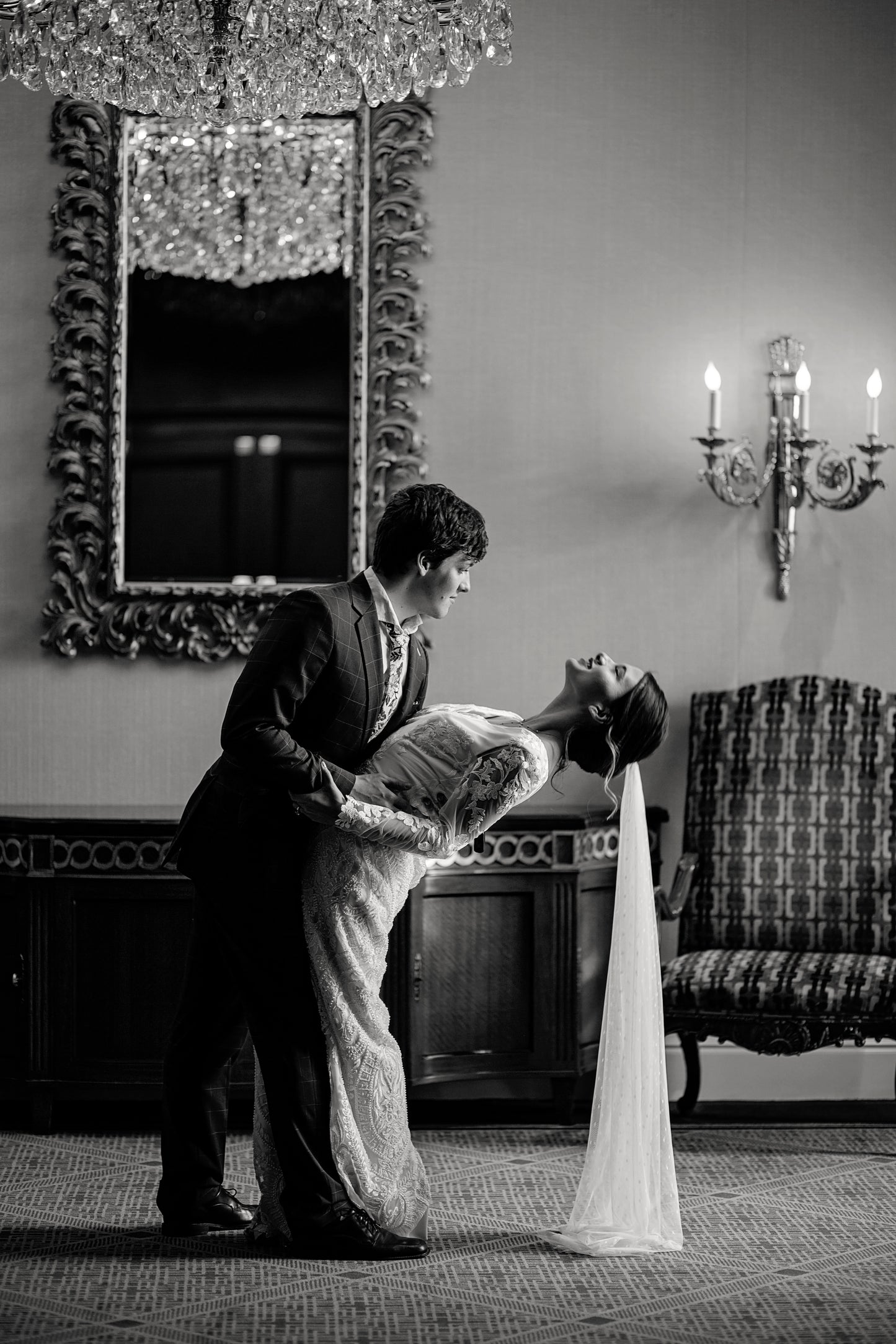 Bride in romantic lace Octavia dress and scarlett veil dipped by groom for whimsical wedding portrait