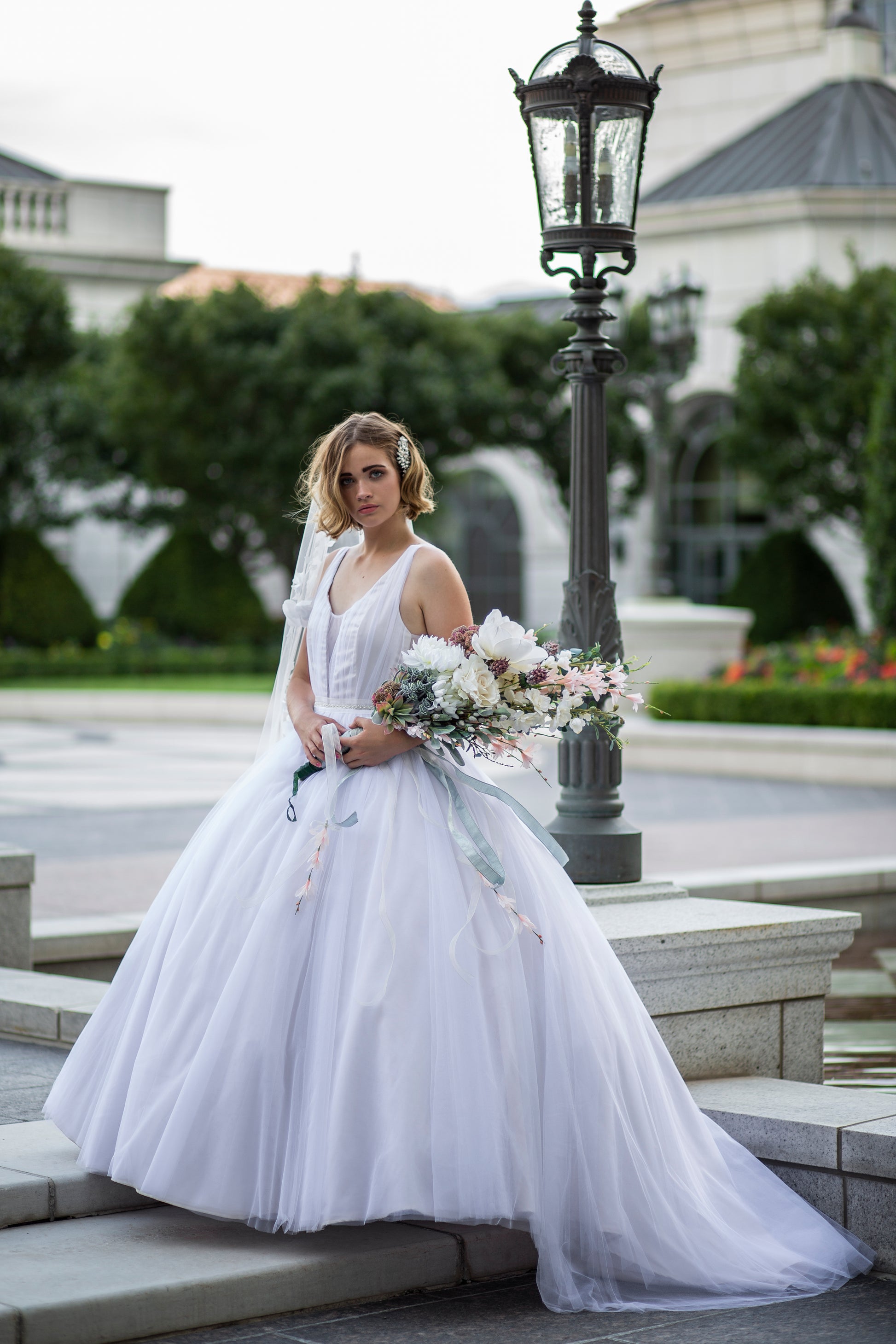 Styled photo of a bride wearing the persephone gown with a petticoat, the gown is extra full and still has a long train.