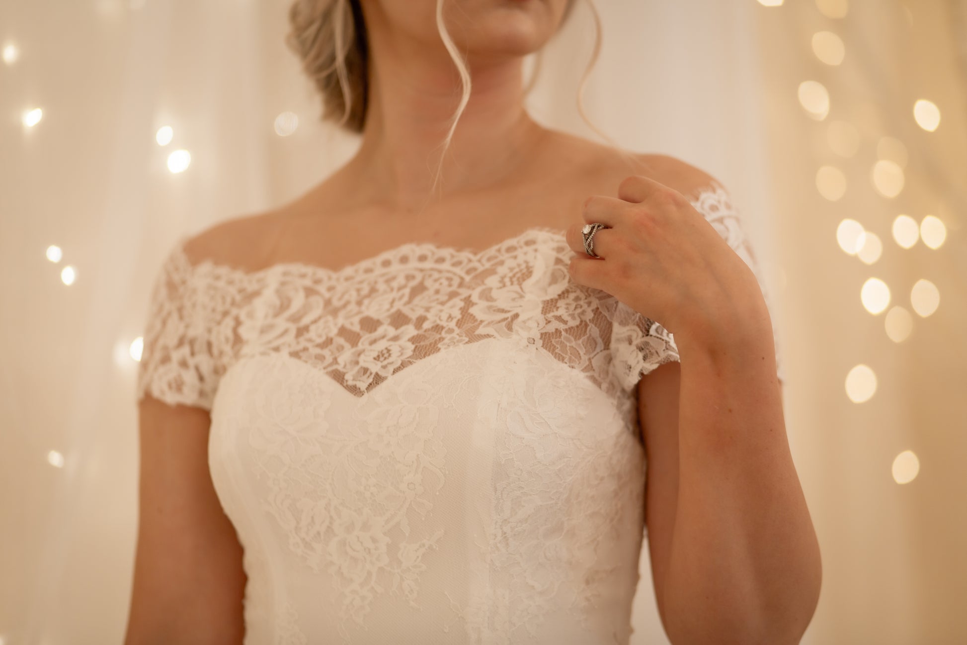 Close-up of scalloped neckline with eyelash lace, sweetheart crepe neckline, and rose pattern on the Serafina gown.