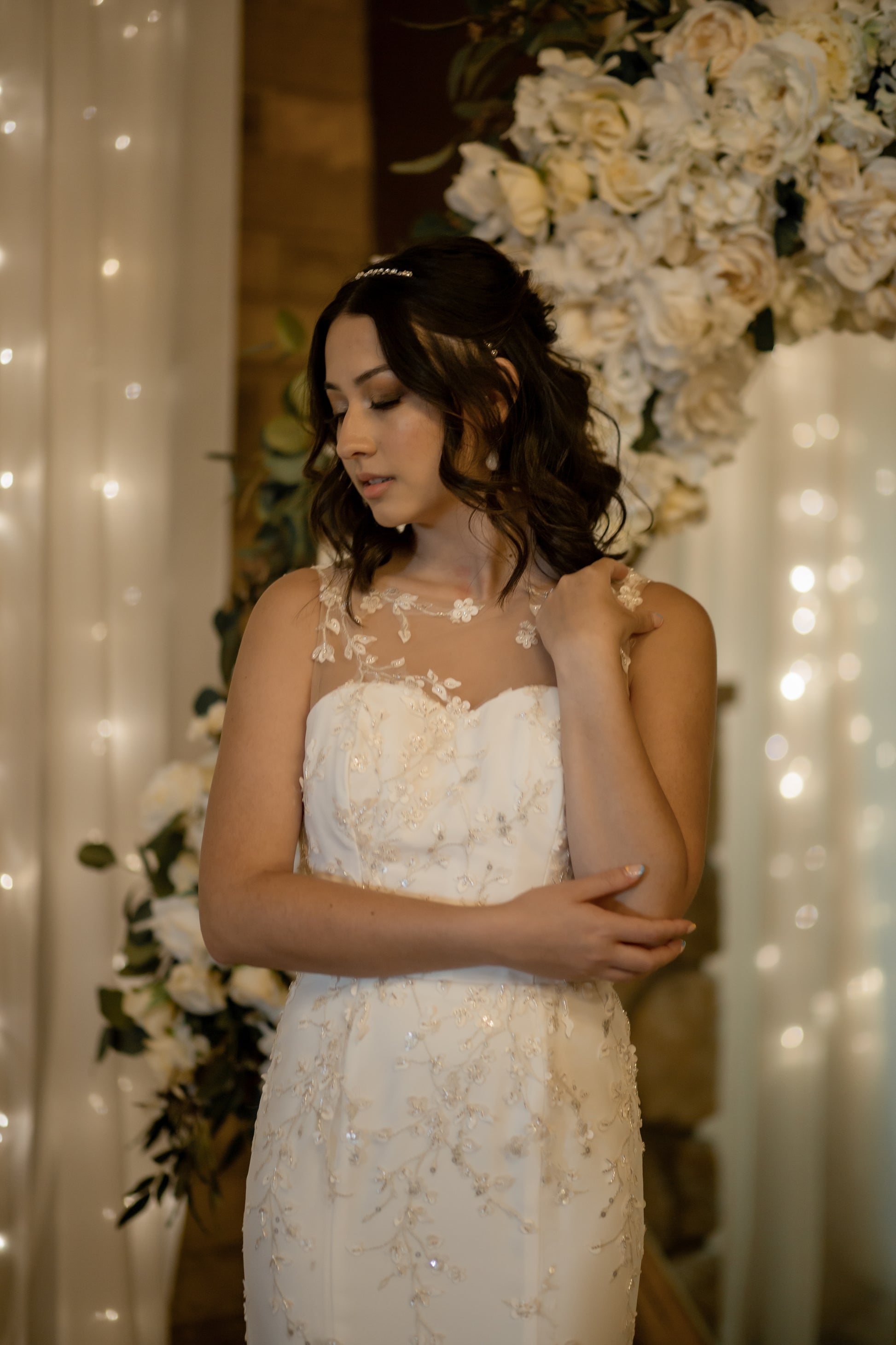 The lorien gown on a bride showing it from the front. The fitted crepe gown with champagne lace is body hugging while the illusion disapears against the skin.